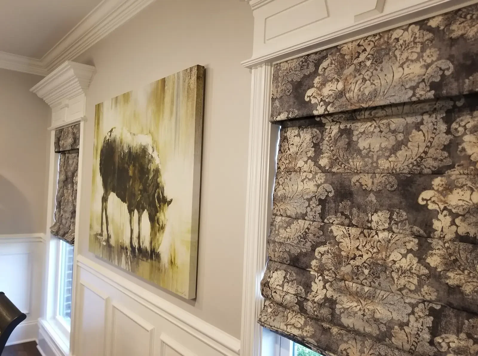 Patterned Roman shades adding interest to dining room windows