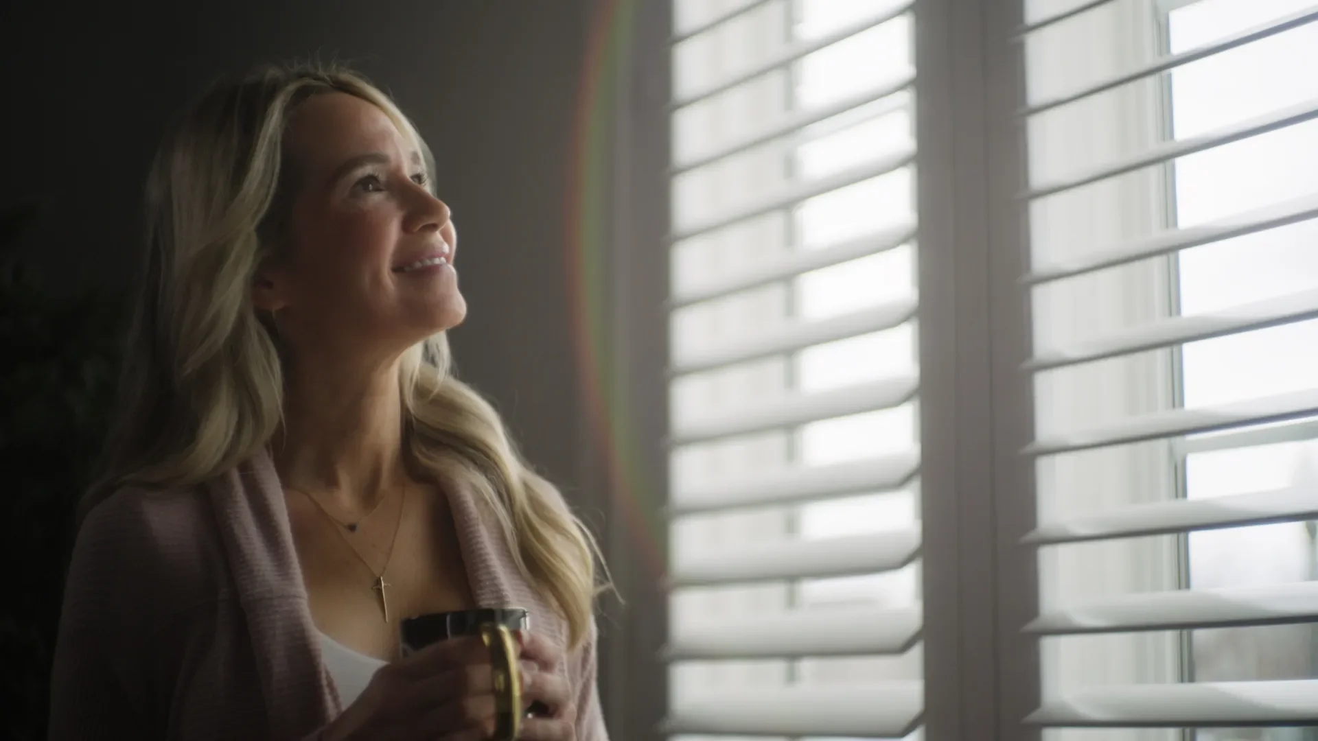 A customer enjoying her shutters installed by Nashville Blinds & Shutters.