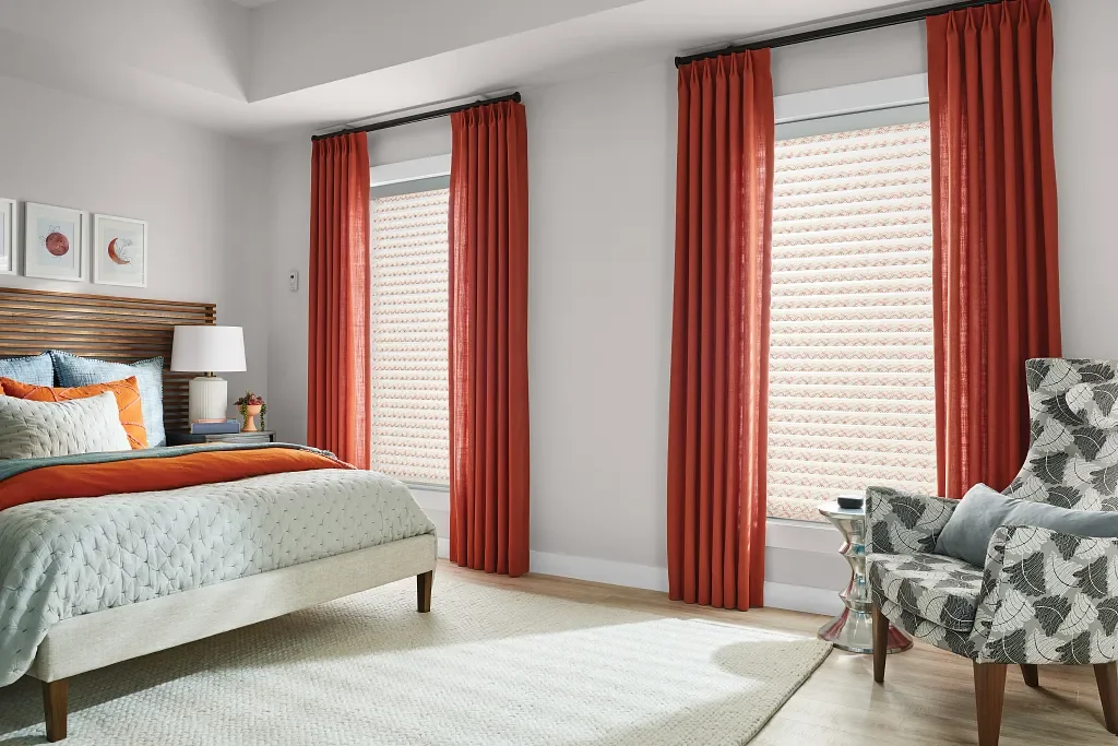 Floor-to-ceiling draperies add a pop of color to this bedroom.