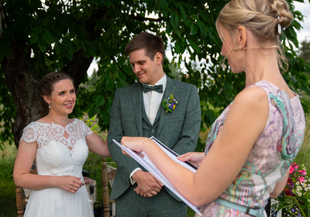 Das Hochzeitspaar steht nah bei einander die Braut stahlt Traurdnerin Ulrike kurz vor dem Ja Wort an