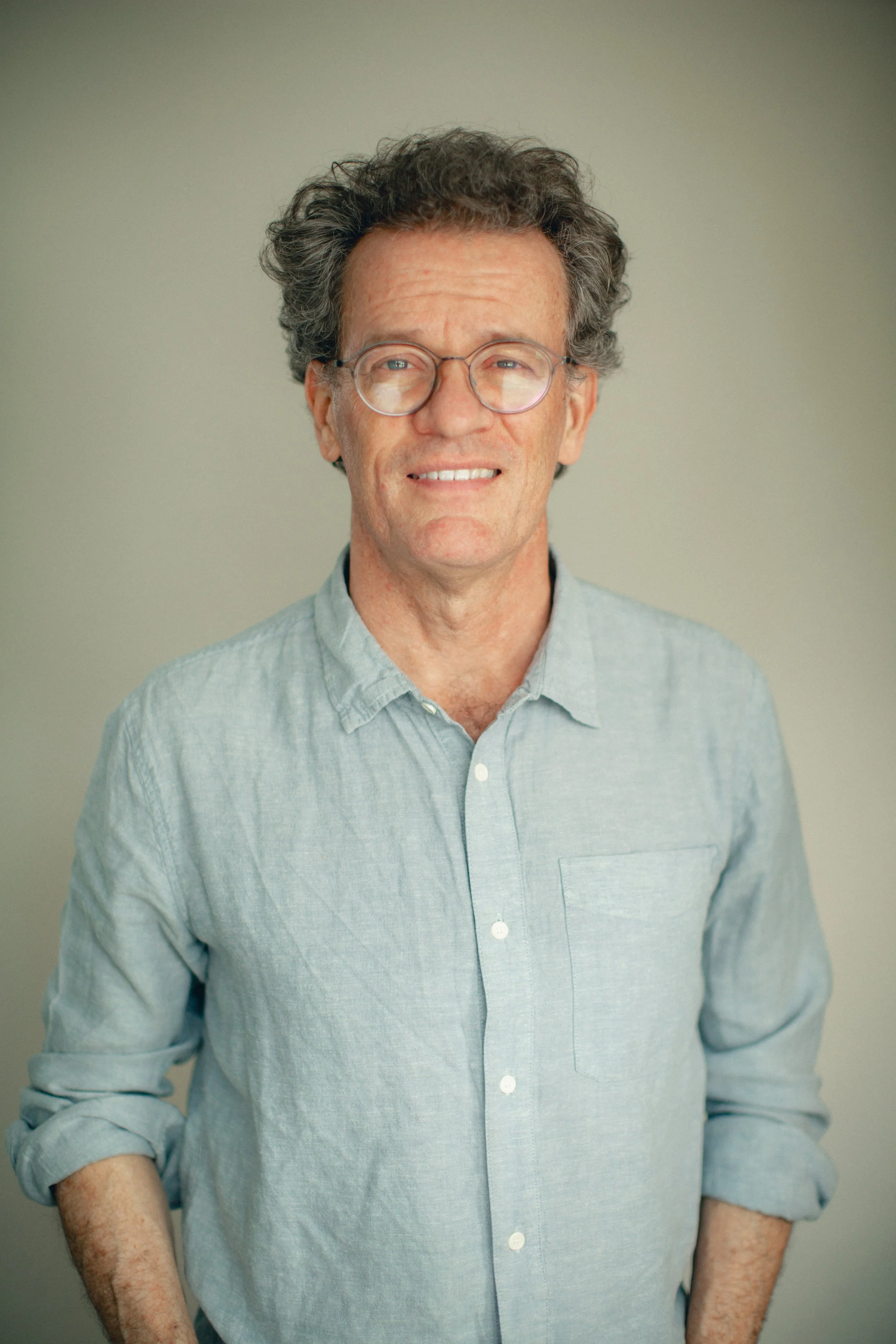Yann Martel smiling, fully facing the camera with a plain background