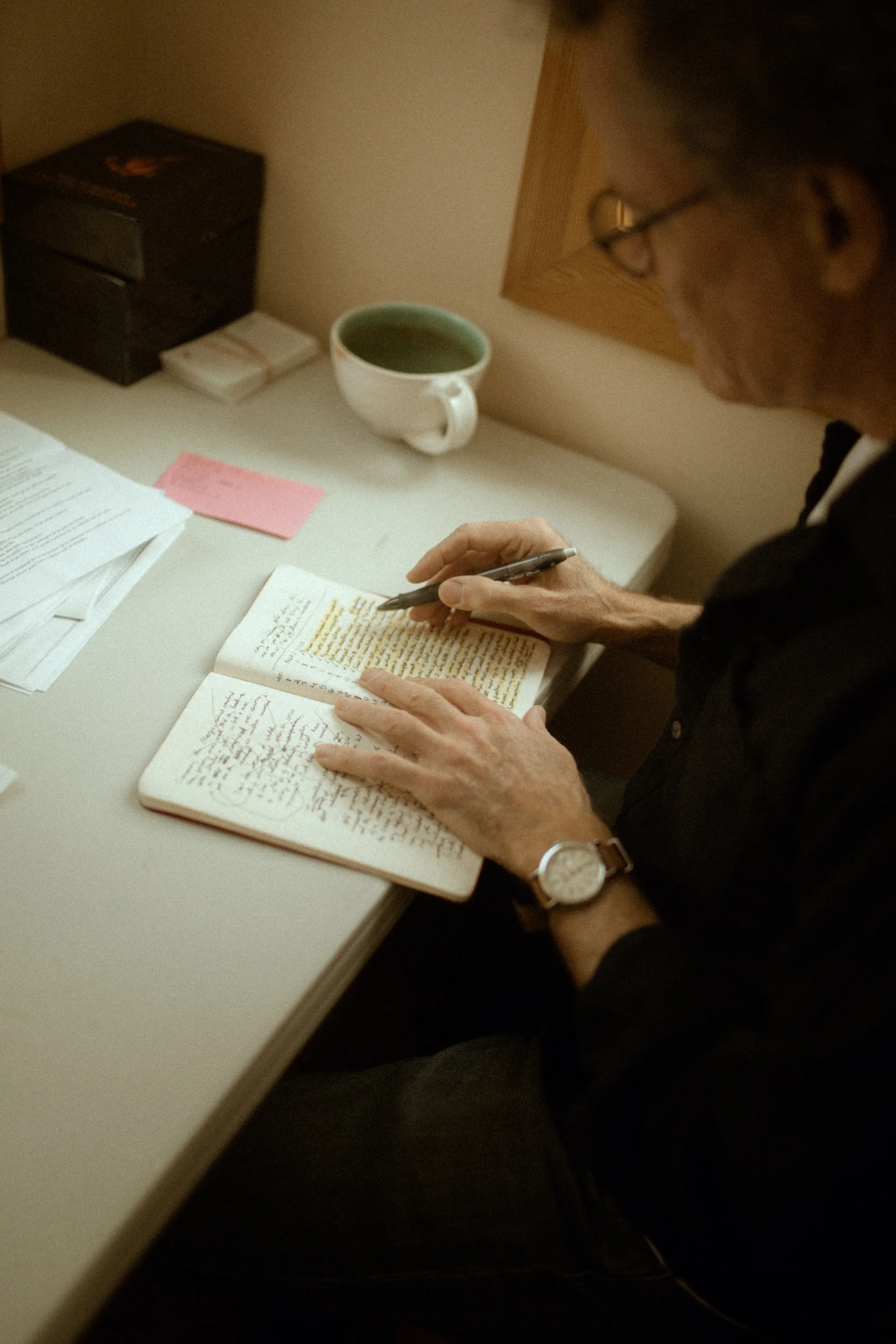 Yann Martel writing in a notebook at a desk