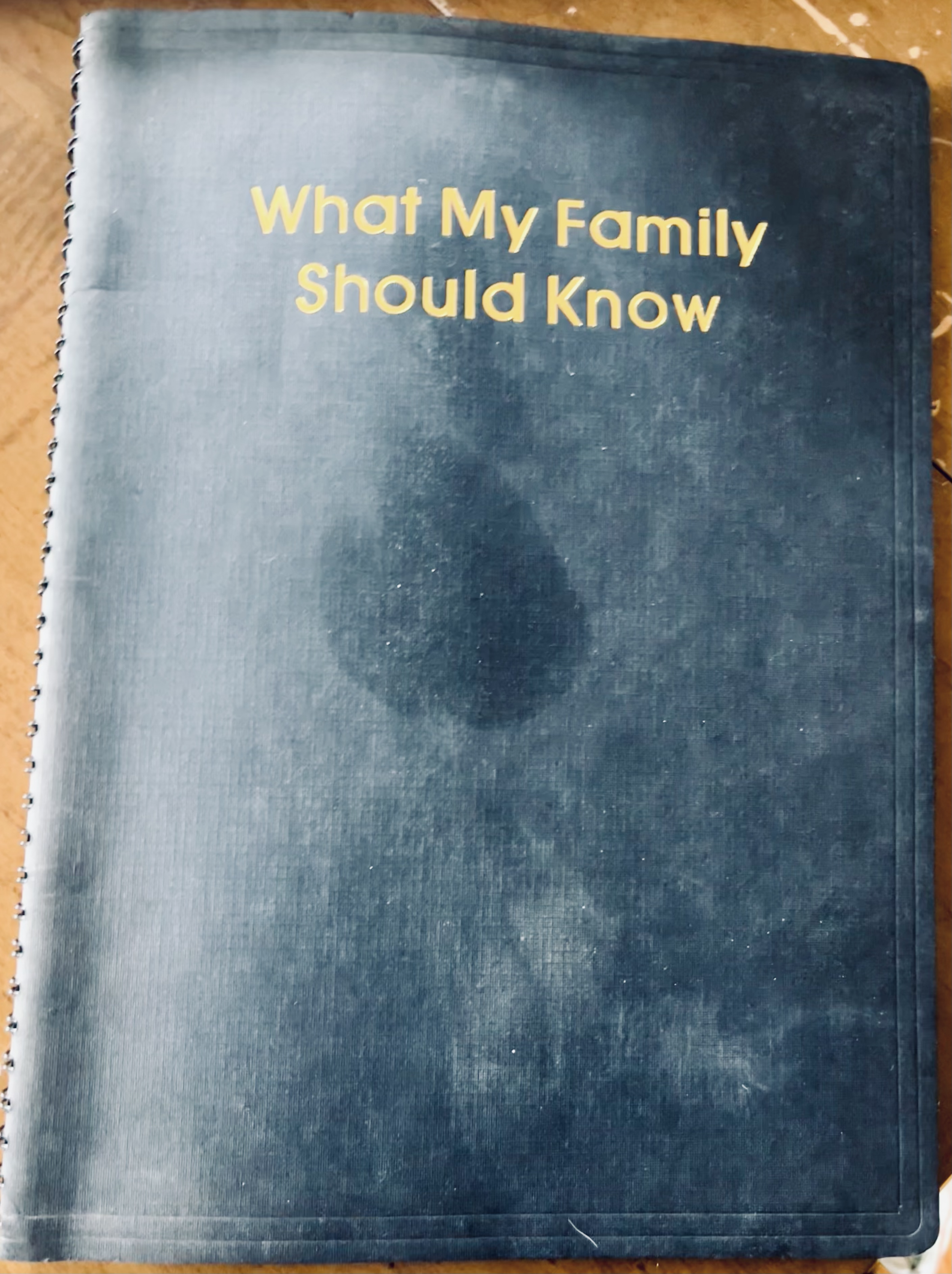 A blue spiral-bound notebook with the title 'What My Family Should Know' written in yellow on the cover.