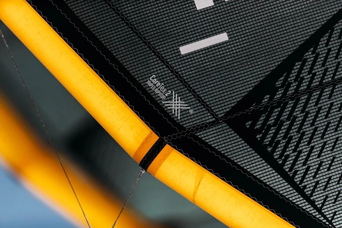 Close-up of a black and gray trampoline safety net with yellow frame and Complete 2 Triple-Triple Ripstop label