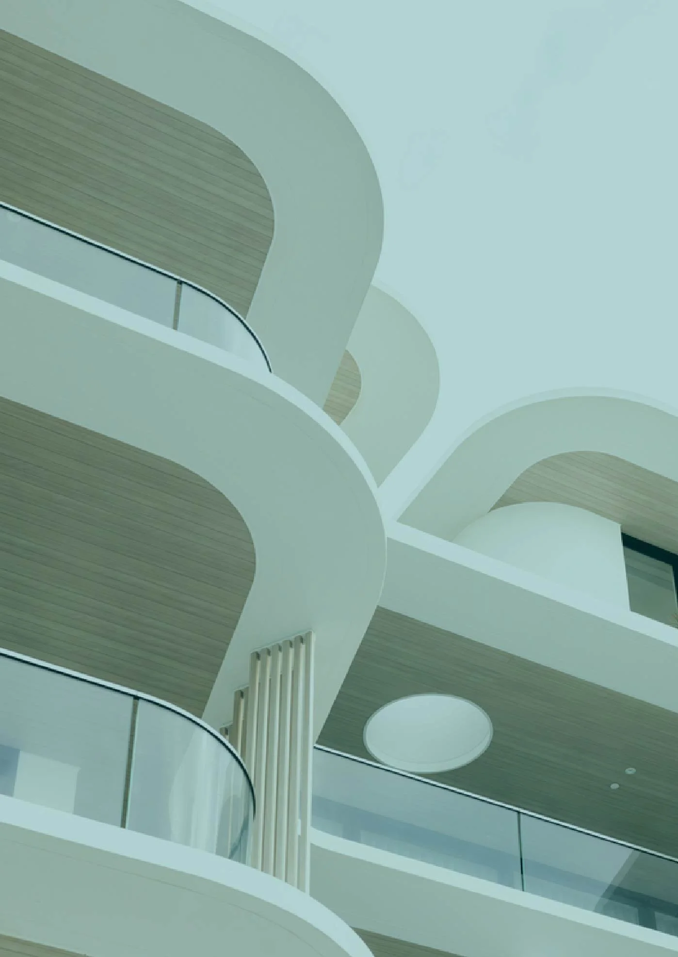 Interior view of a modern building with curved white balconies and wooden accents.
