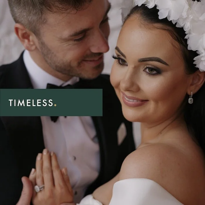 A bride and groom are close together, smiling, with the bride wearing a floral headpiece and the groom in a tuxedo. The word "TIMELESS" is overlaid on the image.