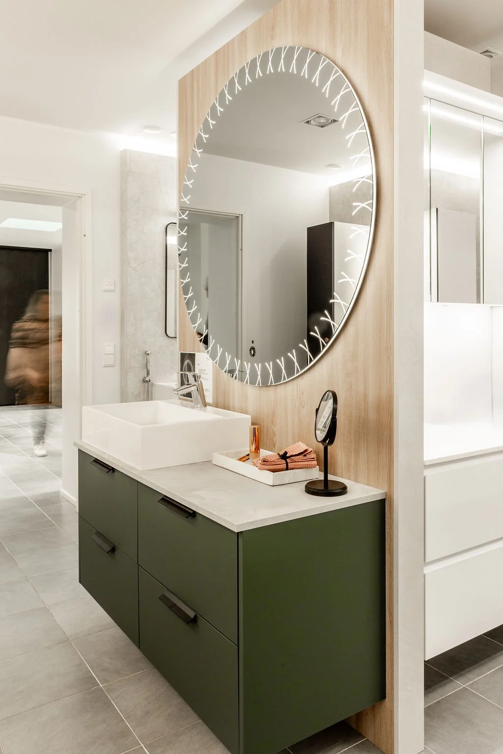 Moderni kylpyhuoneen peiliä, jossa on LED-valaistus, pesuallas ja pieni käsittelypöytä