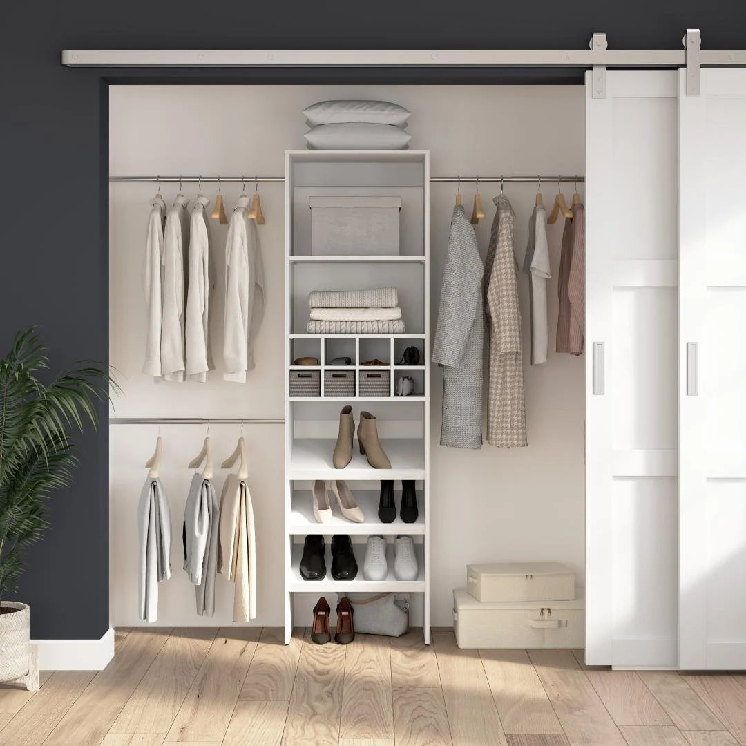Organized closet with hanging clothes, shelves with shoes and accessories, white sliding doors, and a potted plant on the left.