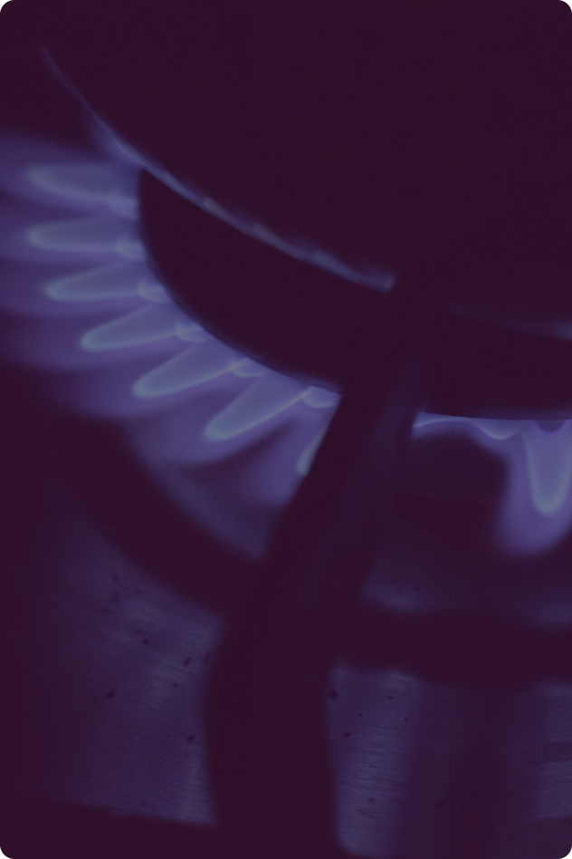 Close-up of a gas stove burner with blue flames.