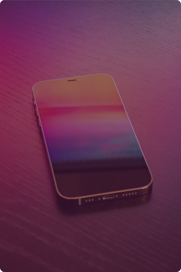 A smartphone resting on a purple wooden surface with a gradient-colored screen.