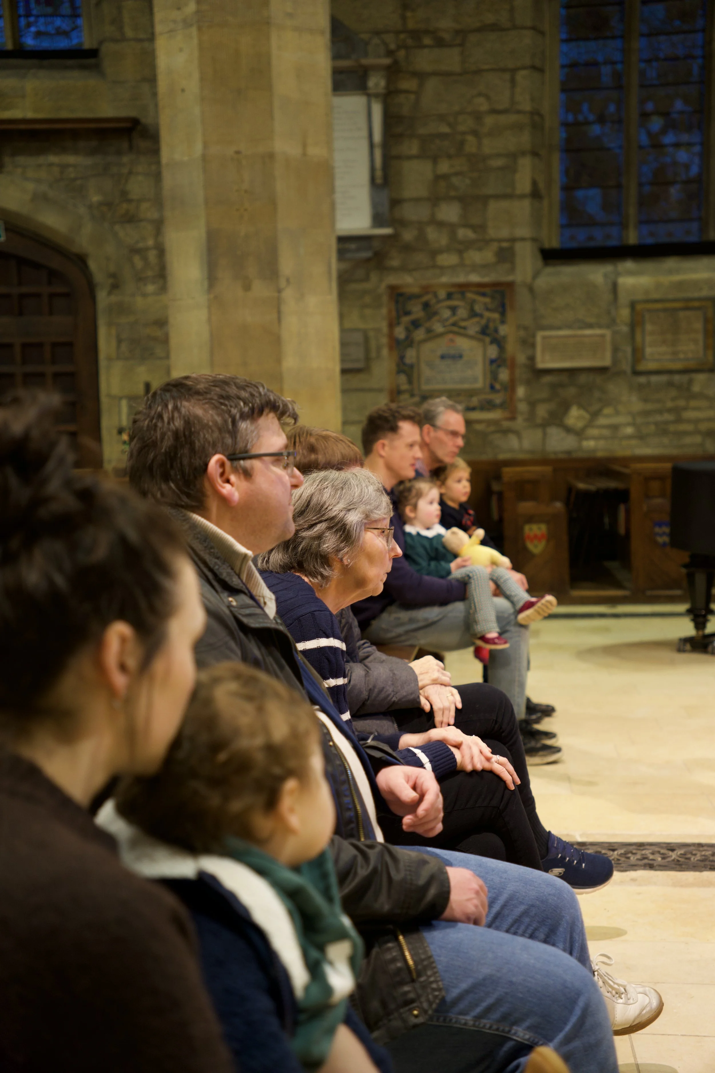 People sitting in a church, attentively watching a performance, presentation, or sermon.