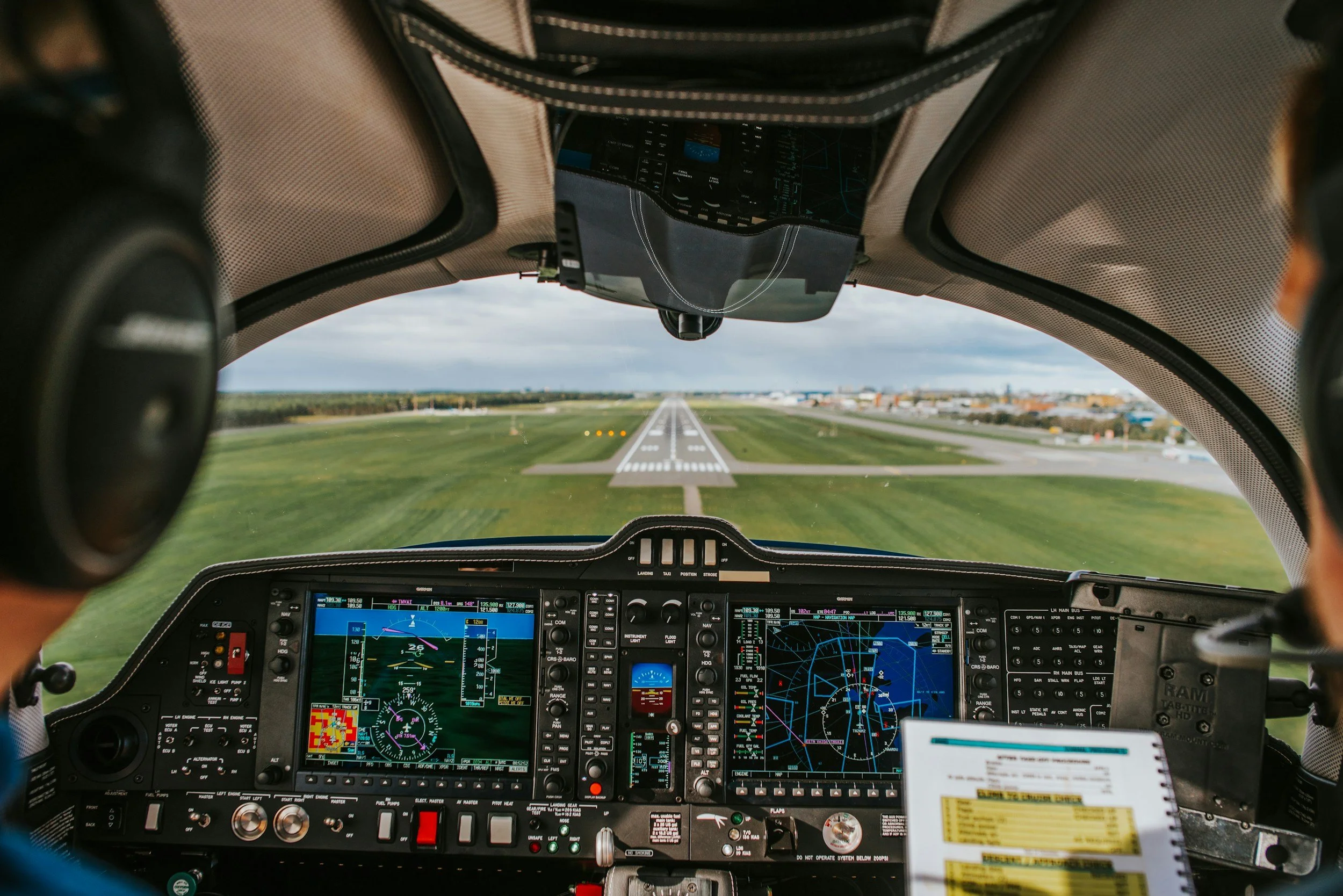 Inside view of an aircraft cockpit preparing for takeoff, showing the runway ahead and various flight instruments on the dashboard.