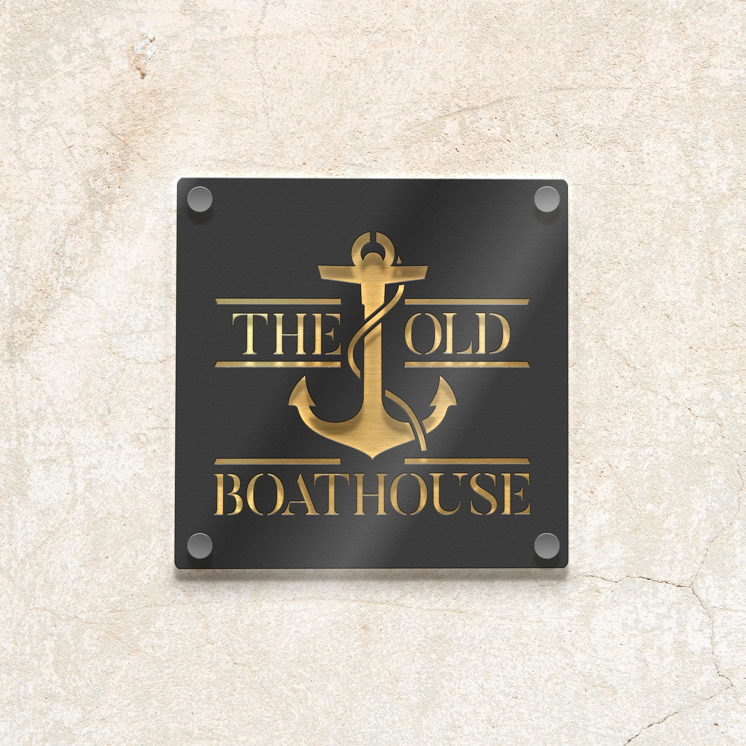 Black square plaque with gold text and anchor design reading "The Old Boathouse" mounted on a beige textured wall.