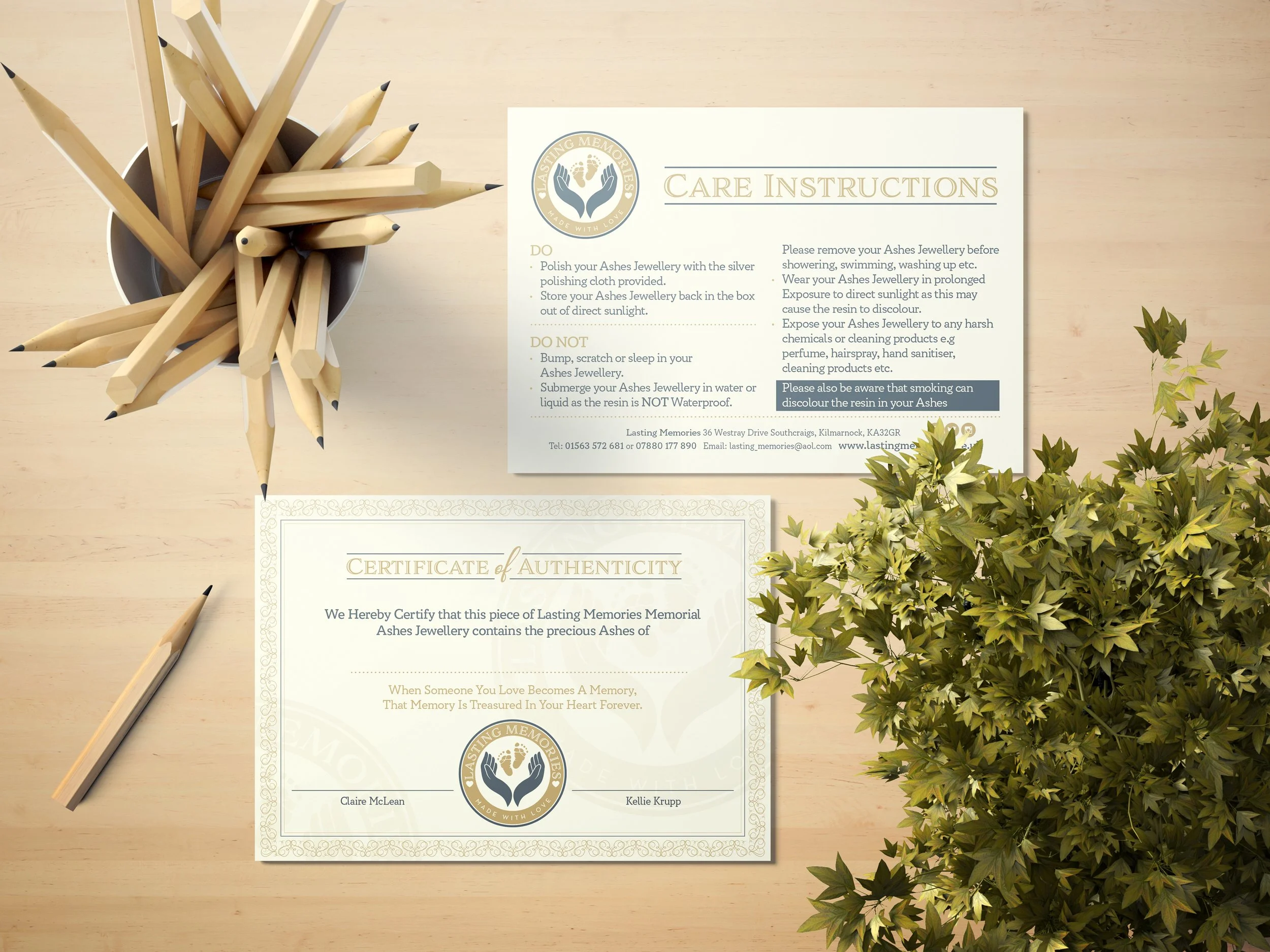 A wooden table with a container of white pencils, a printed care instruction sheet, a certificate of authenticity, a gold pen, and a potted green plant.