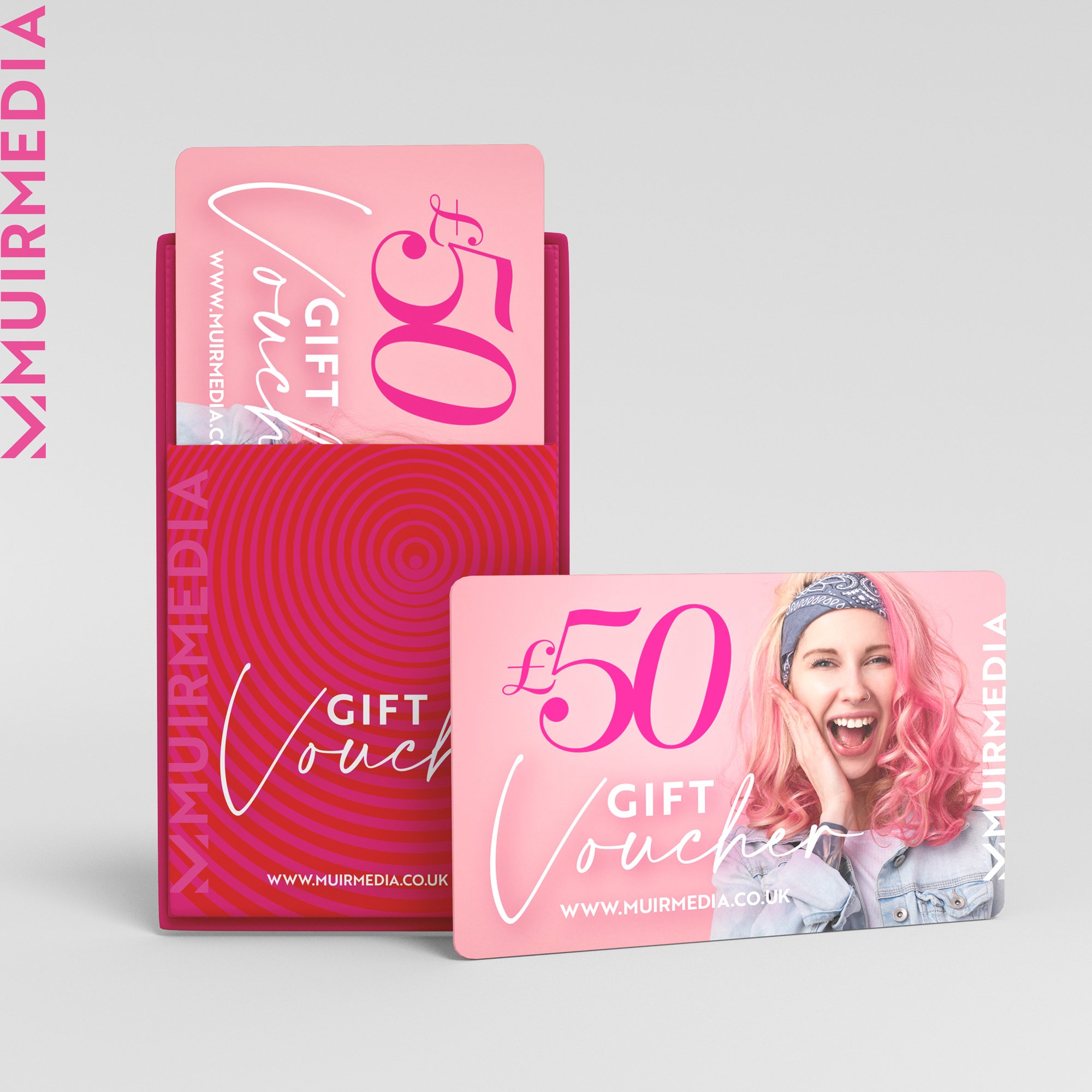 A pink gift card with a smiling woman with pink hair, wearing a bandana, on it, and an upright red box with a pink gift card inside. The gift card has a £50 value and the website www.muirmedia.co.uk printed on it.