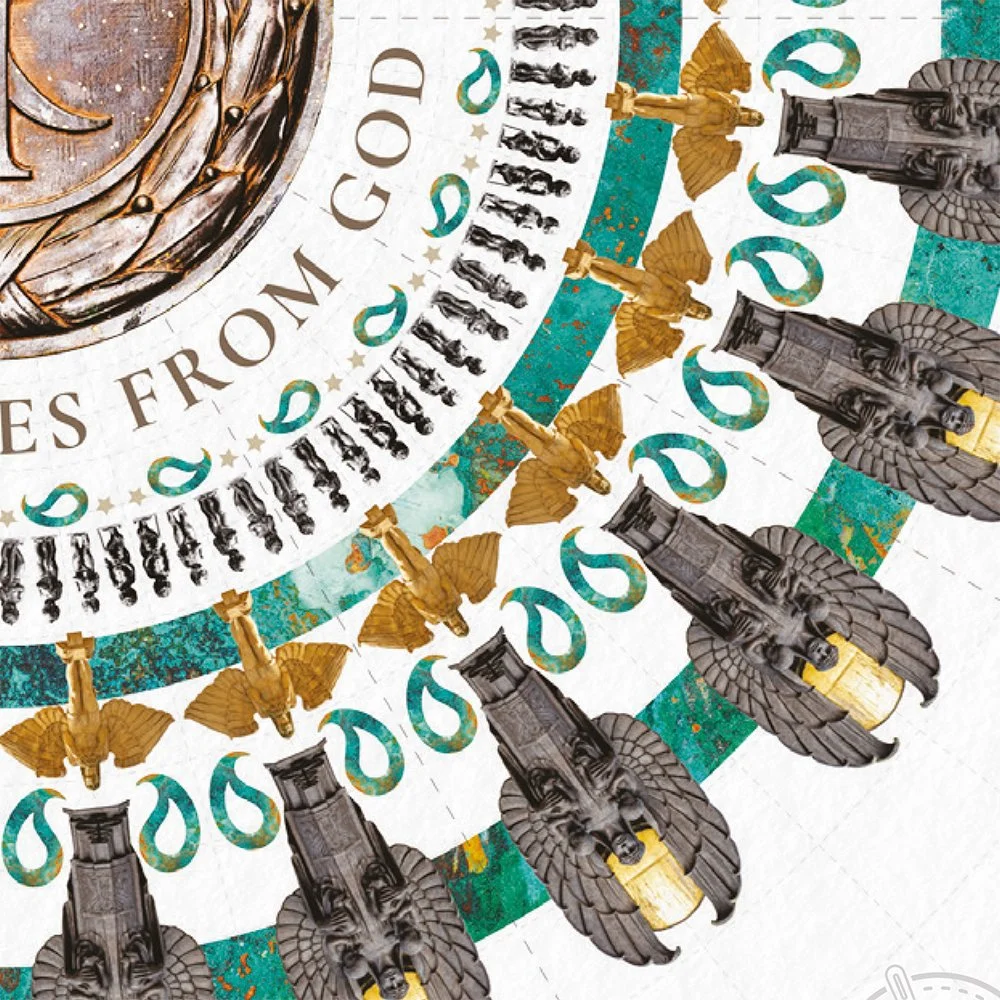 Close-up of a decorative coin with detailed golden and dark gray lion head figures, goldwinged figures, teal decorative elements, and the partial phrase 'ES FROM GOD'.