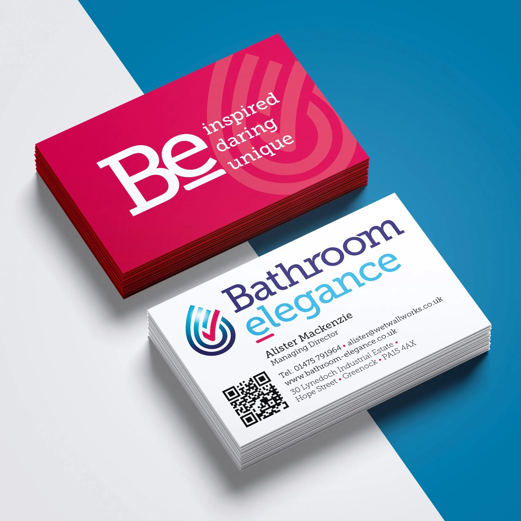 Stack of business cards with one set reading 'Be inspired daring unique' in white text on a pink background and another set reading 'Bathroom elegance' with contact details and a logo on a white background.