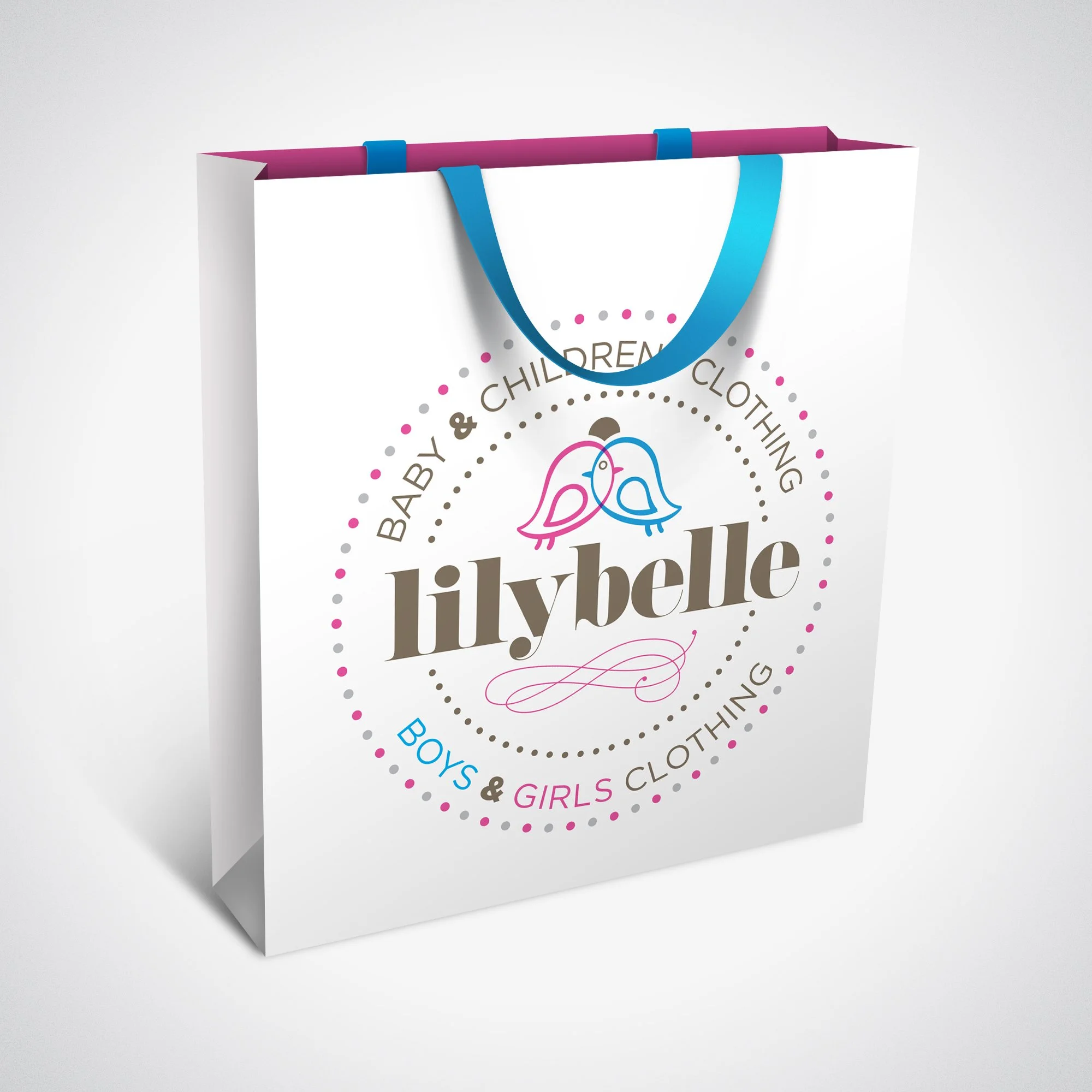 White shopping bag with pink and blue handles, featuring a logo with two birds and the text "lily belle", promoting baby & children clothing for boys and girls.