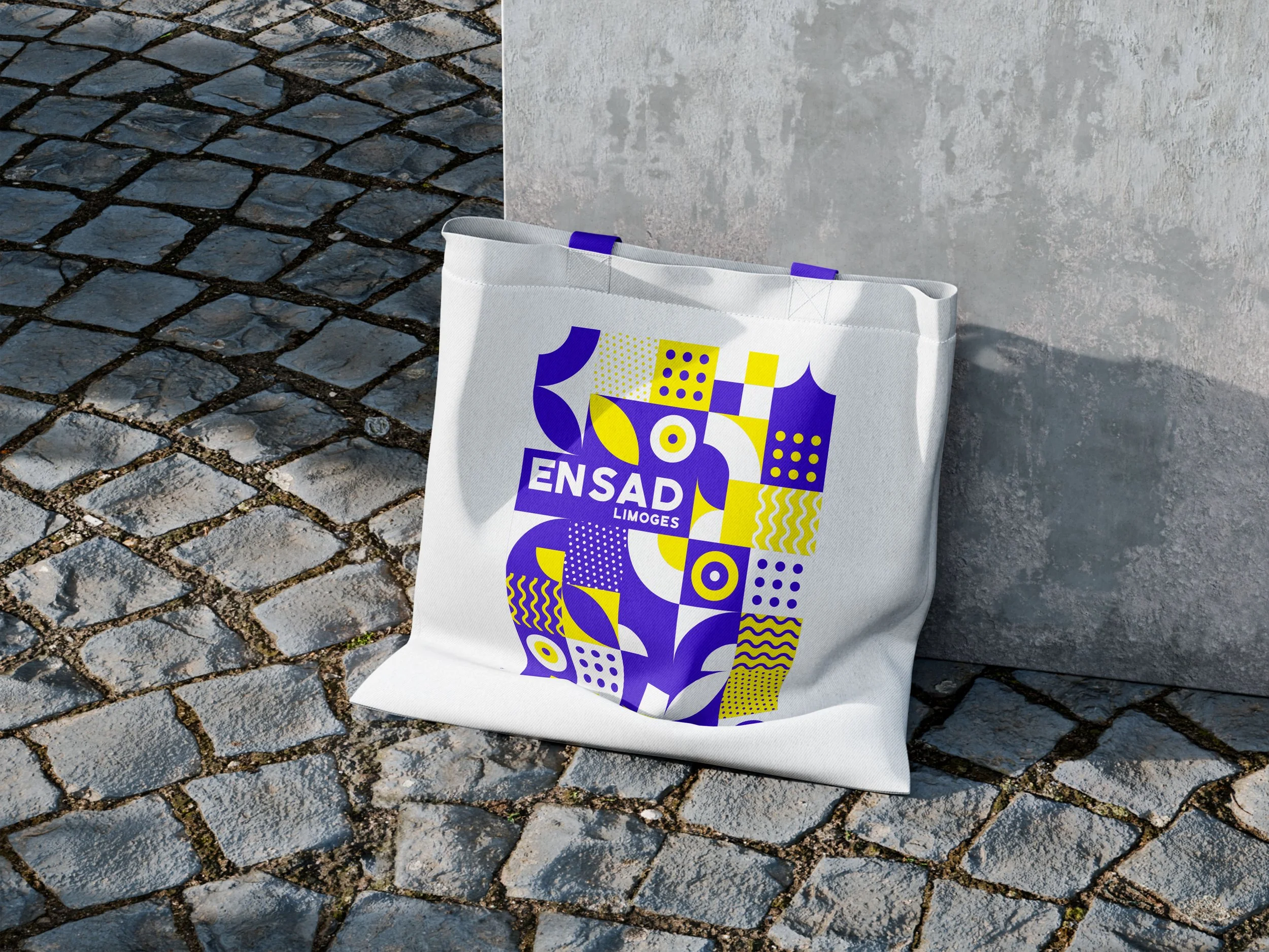 Tote bag ENSA Limoges : branding textile aux motifs géométriques bleus et jaunes. Support de communication pour l'École Nationale Supérieure d'Art, design graphique par Bower Studio.