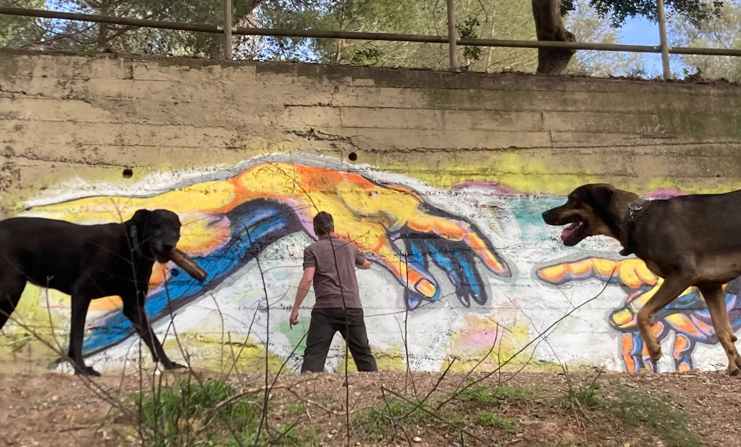 Matthew Rush Elmore working on exterior mural of Adam and God.