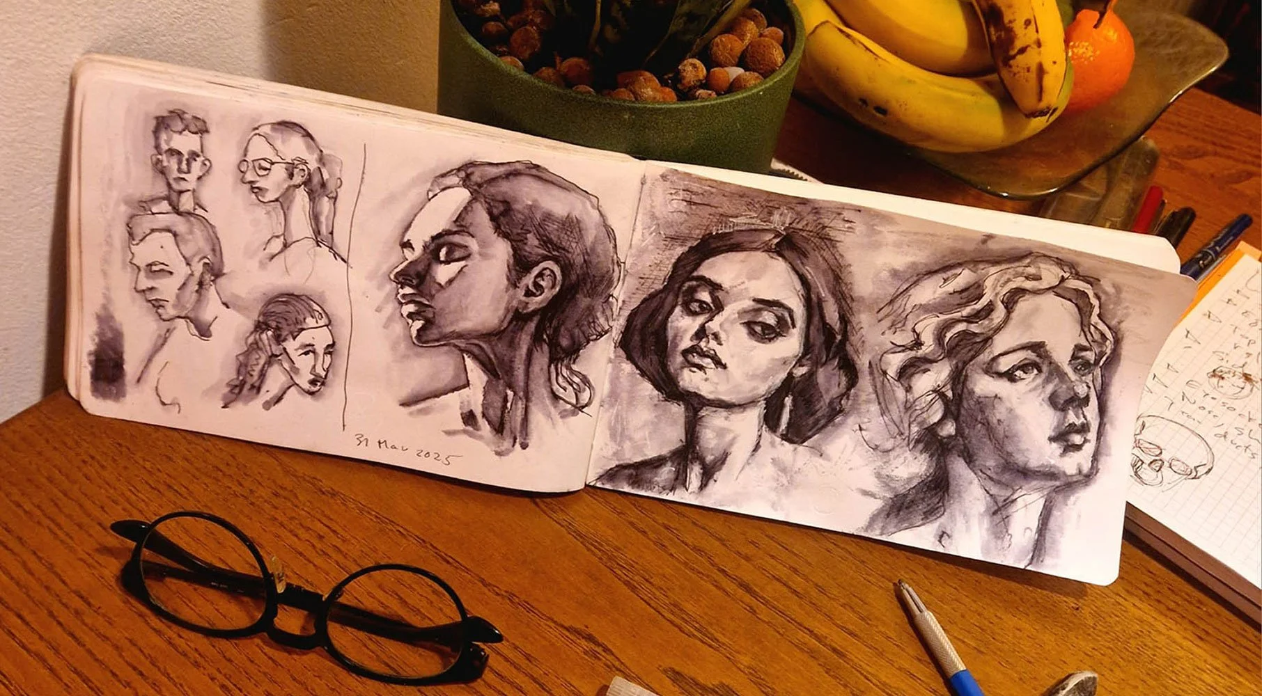 Photo of faces in Matthew Rush Elmore's sketchbook.