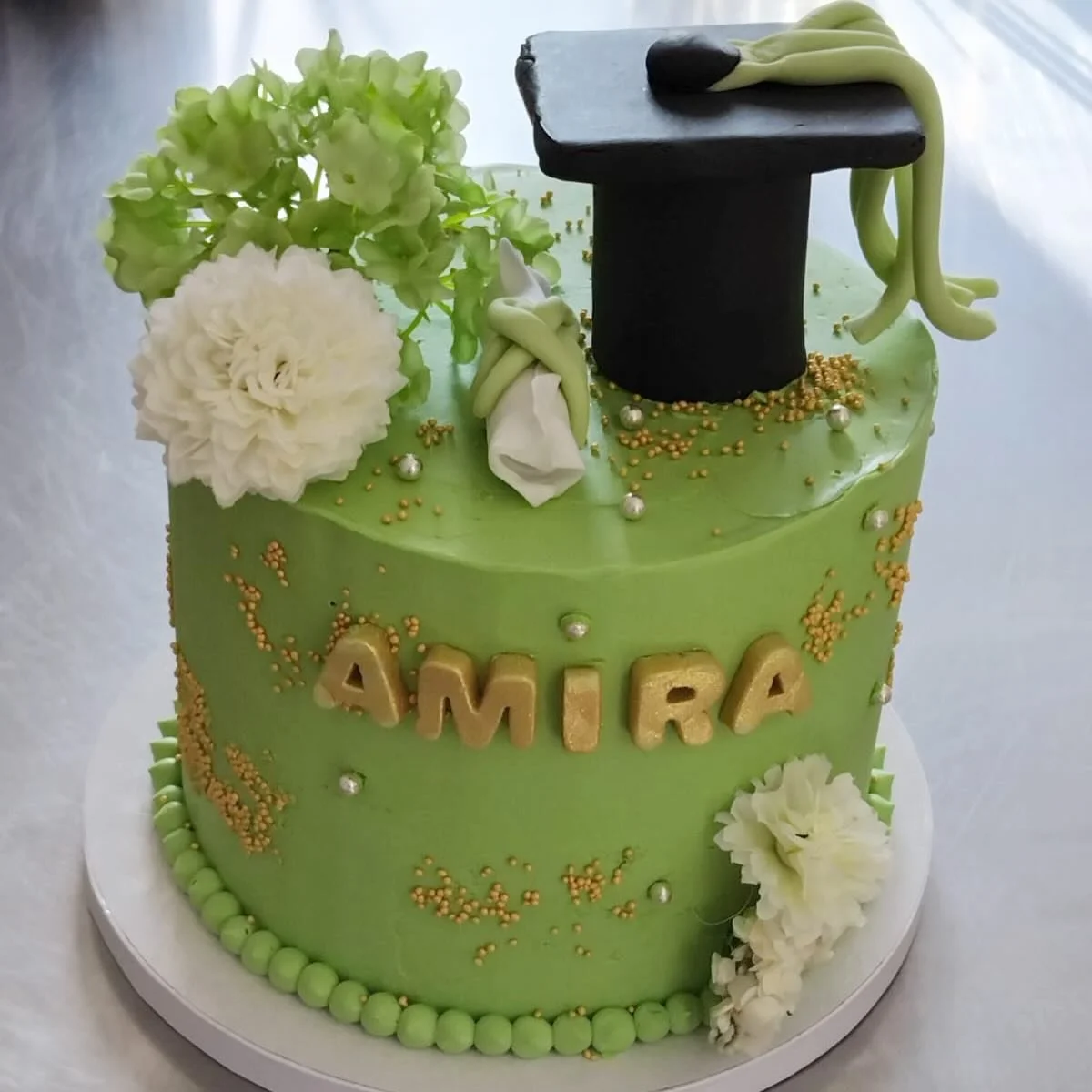 ✨ Amira &ndash; Future Avocate 🎓

👩🏻&zwj;⚖️ D&eacute;cor&eacute; d&rsquo;un mortier d&rsquo;avocate en p&acirc;te &agrave; sucre, sublim&eacute; par de d&eacute;licates fleurs blanches

🍰 C&ocirc;t&eacute; saveurs :
&bull; Biscuit vanille moelleu