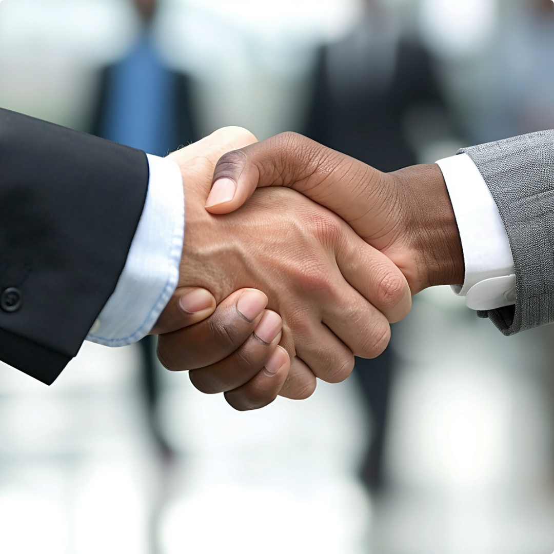 Two people in business suits shaking hands.