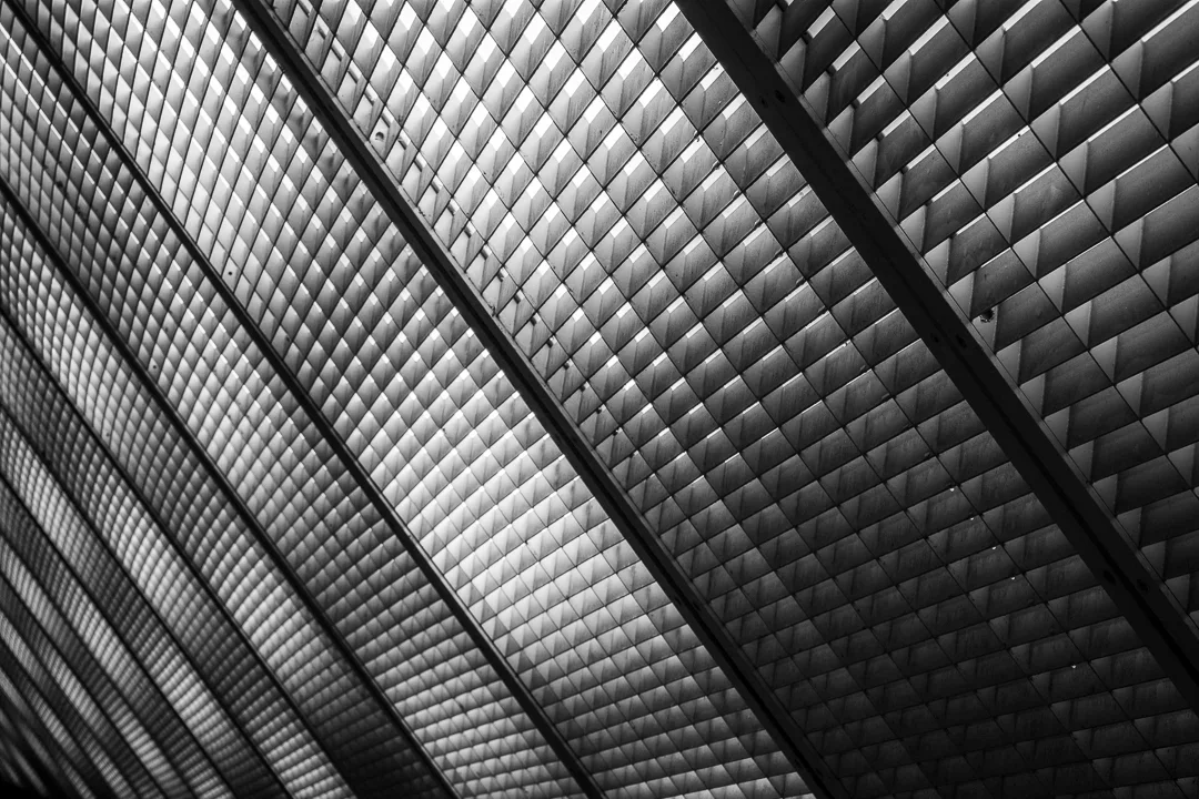 Close-up van een modern gebouw met een geometrisch patroon van metalen panelen in zwart-wit.