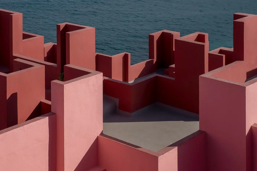Moderne bouw met roze muren en gekleurde geometrische vormen aan de kust
