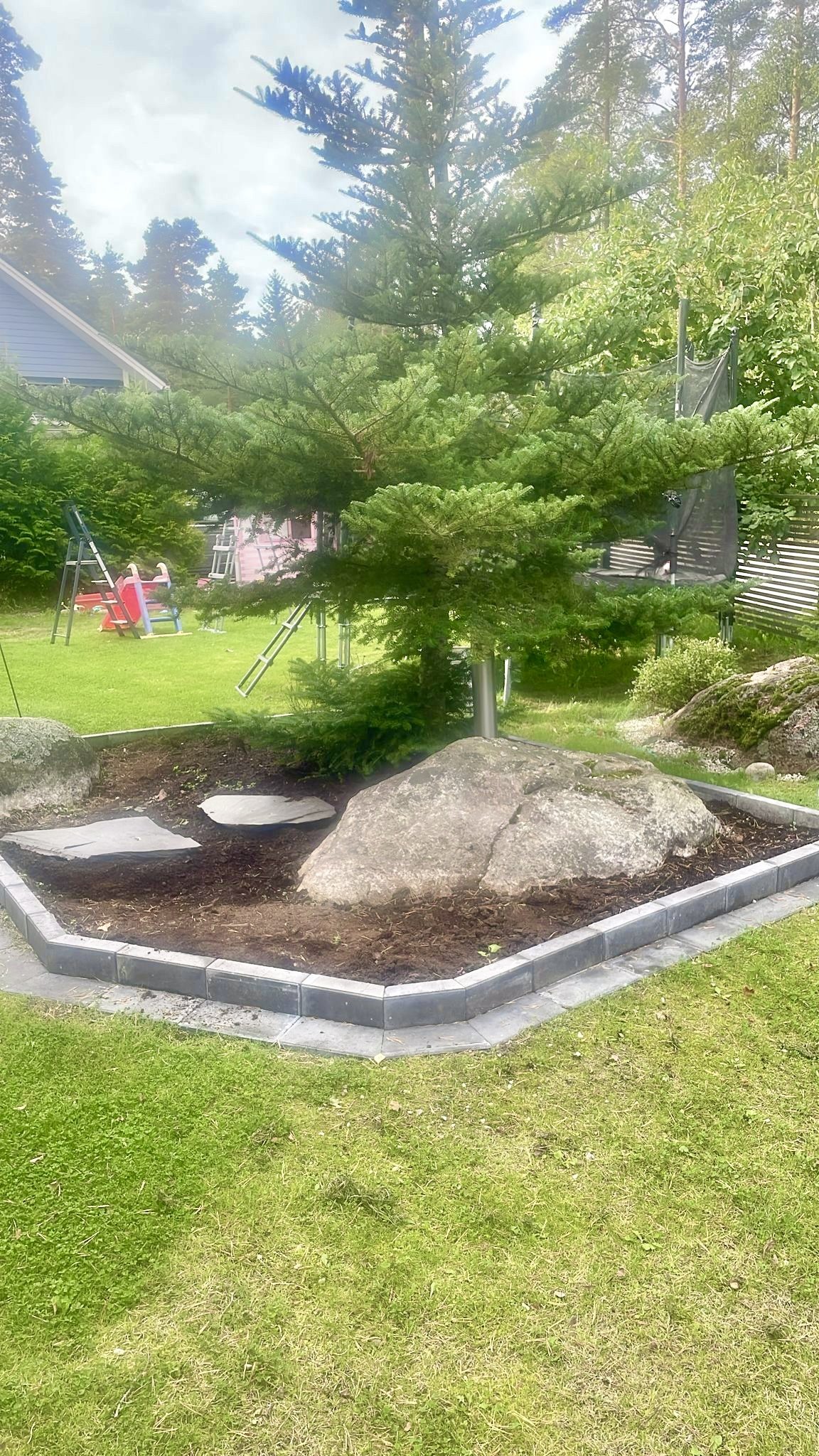 Puutarhan istutusalue ja tiilirakenne jälkeen