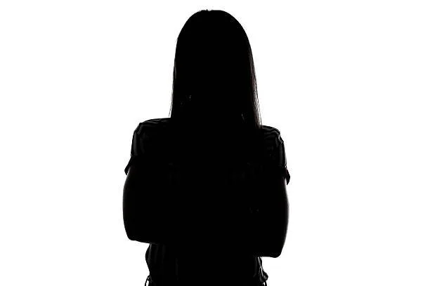 Silhouette einer Frau mit verschränkten Armen vor weißem Hintergrund.