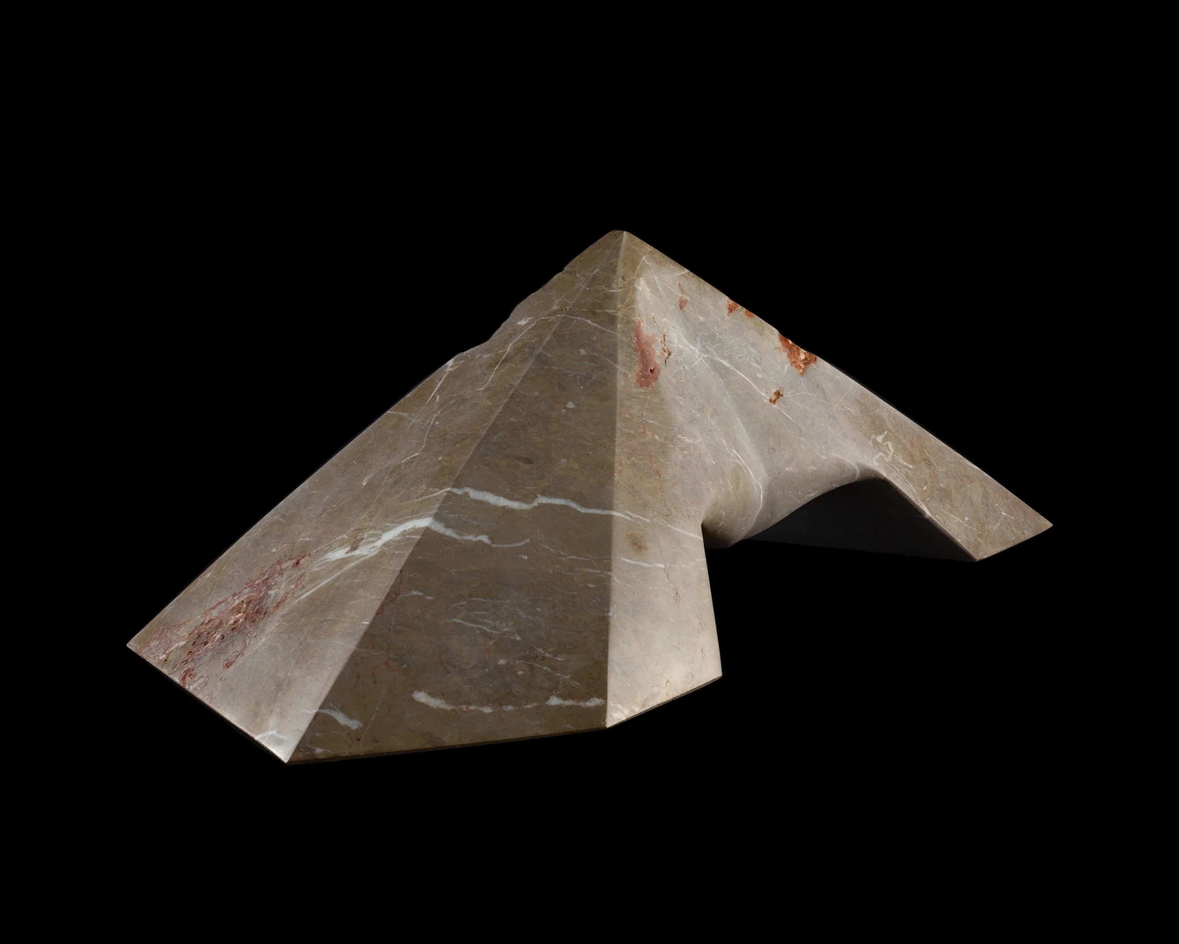 A close-up of a marble sculpture with sharp angles and a smooth, polished surface, displayed against a black background.