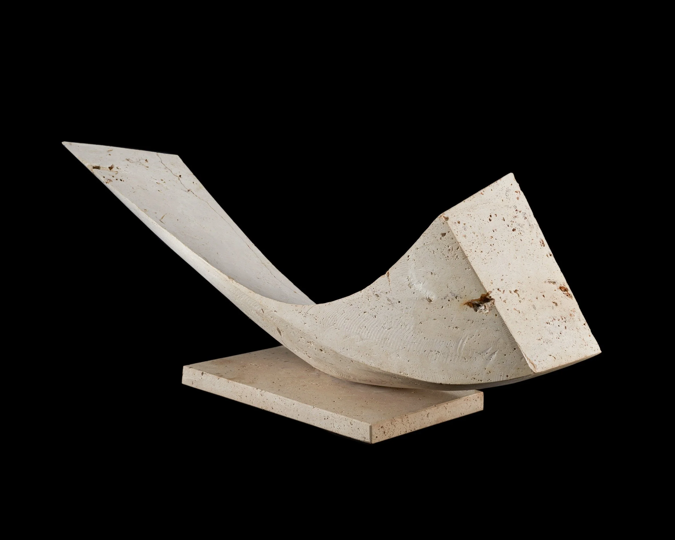 Abstract sculpture made of white stone or marble, with curved and angular shapes, placed on a black background.