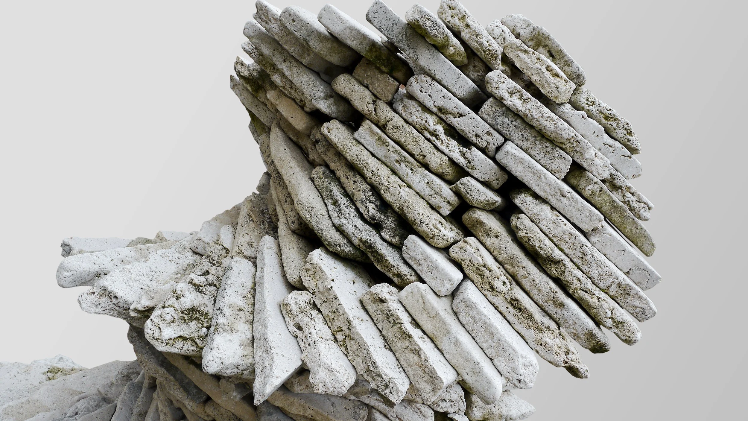 Close-up view of a sculpture made from stacked white stones forming a spiral shape.