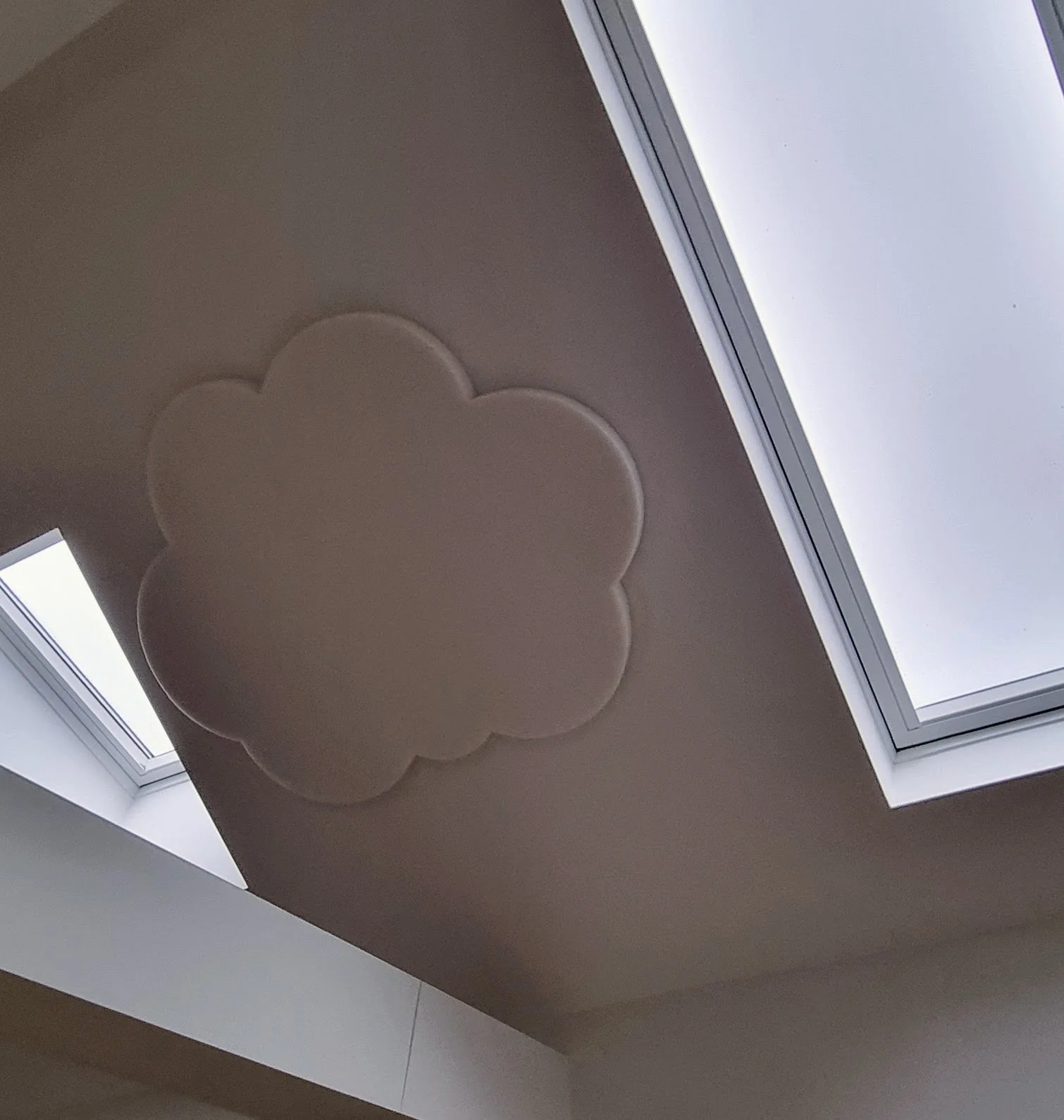 Ceiling with skylights and a decorative cloud-shaped element.