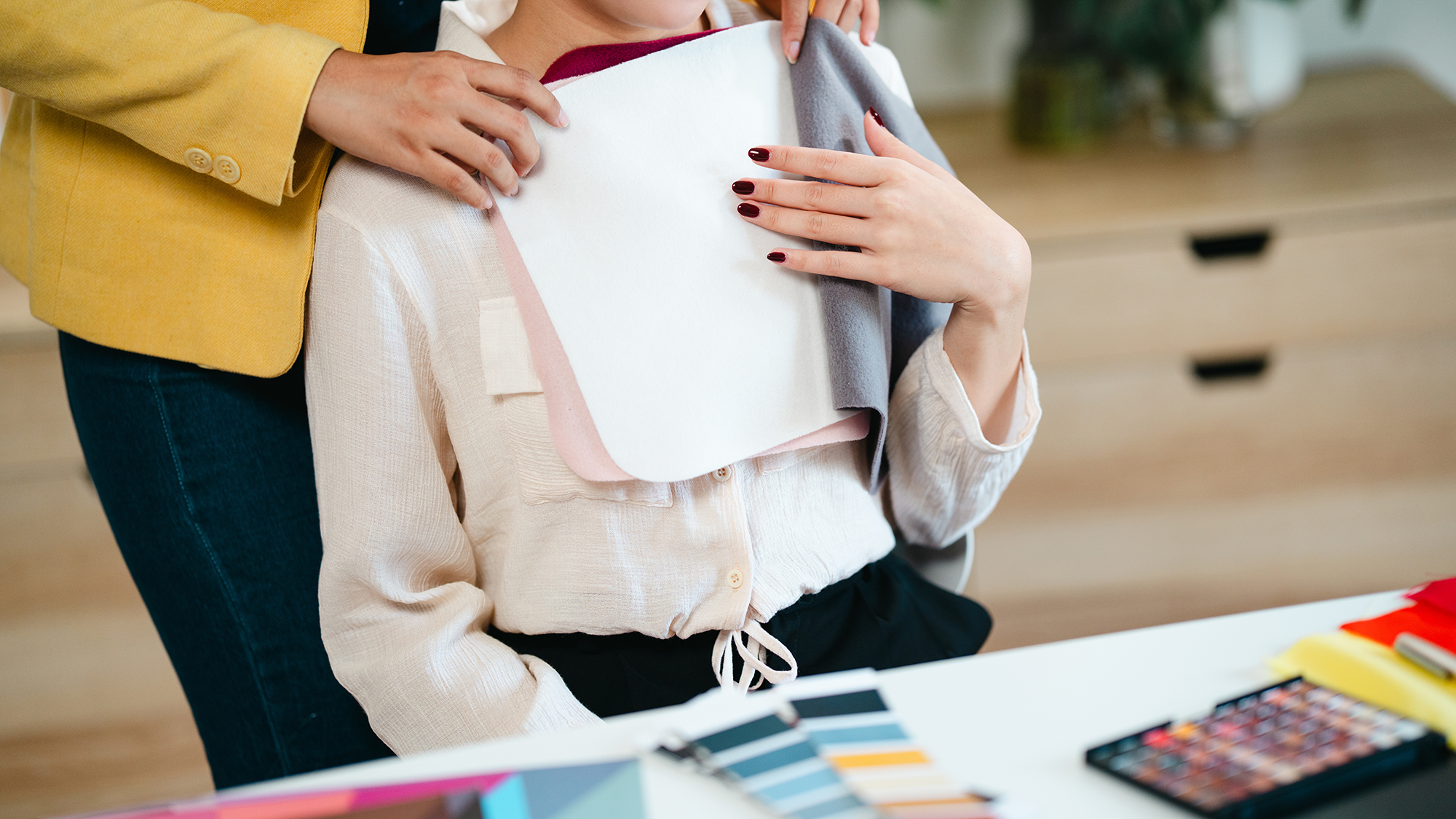 Henkilö asettaa värikkäitä kangasnäytteitä värianalyysissä.