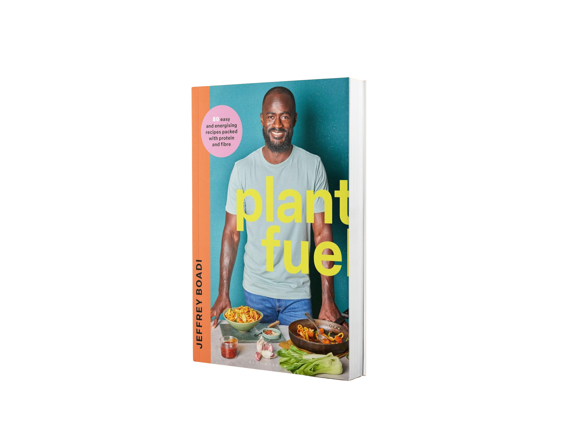 Book titled 'Plant Fuel' by Jeffrey Boadi, featuring a smiling man with a beard wearing a light green T-shirt, standing behind a kitchen counter with a bowl of pasta, a frying pan with food, garlic, fresh vegetables, and condiments.