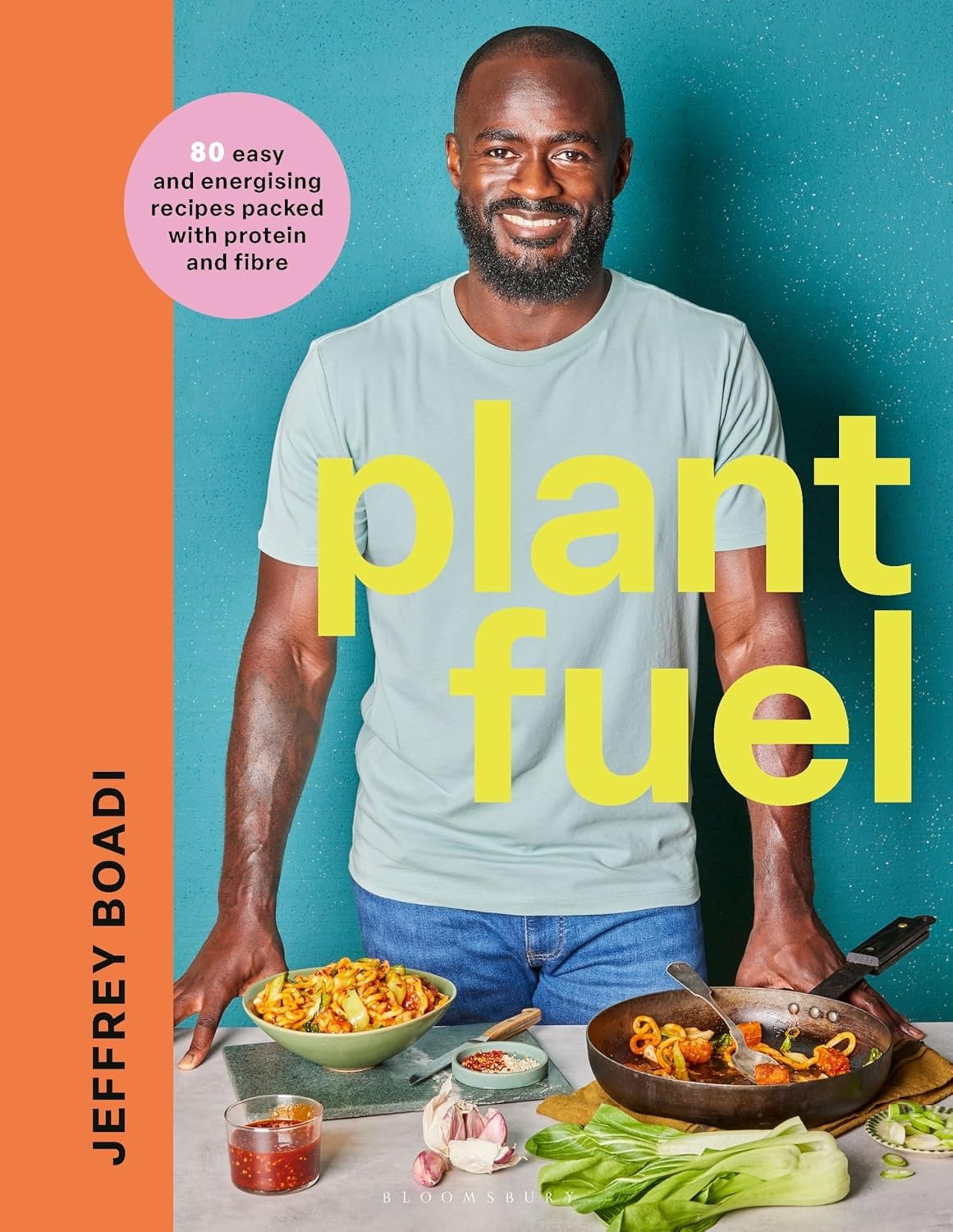 Cover of a magazine featuring a smiling man standing behind a table with a bowl of pasta and various vegetables, promoting plant fuel recipes with a pink circle indicating 80 easy recipes packed with protein and fiber.