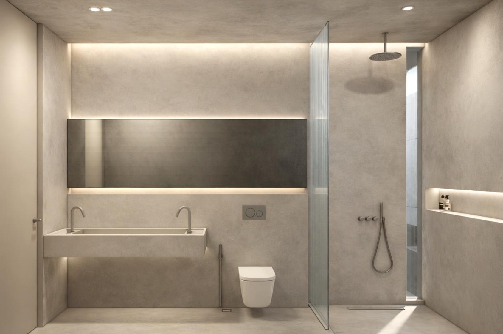 Modern minimalist bathroom with a wall-mounted toilet, a long rectangular sink with two faucets, a large horizontal mirror, a shower area with a rain shower head and handheld shower, and a built-in shelf with toiletries, all in neutral tones with soft lighting.