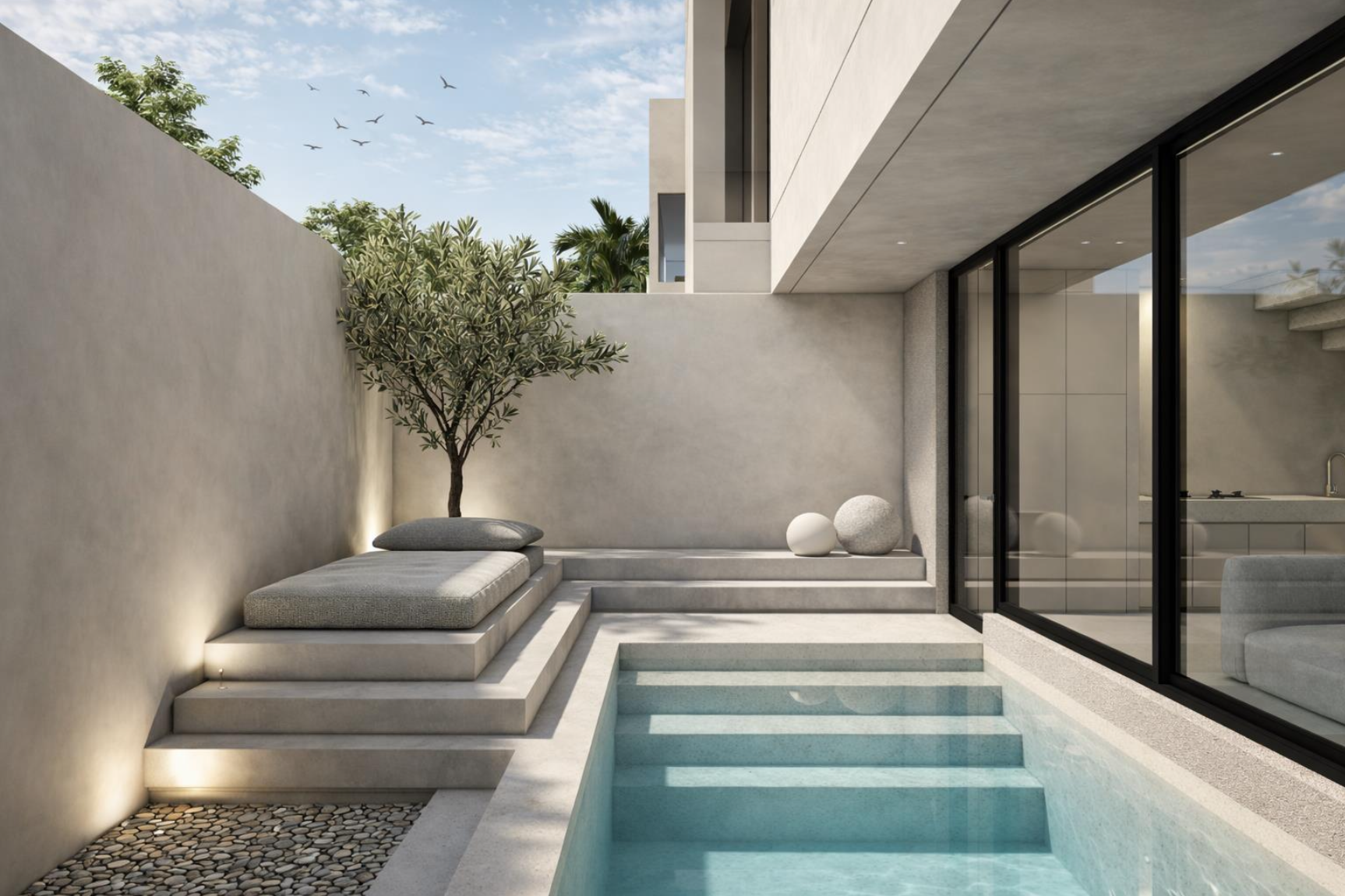Modern backyard with a small swimming pool, outdoor lounge area with cushions, a tree, decorative stones, and glass doors leading inside the house.