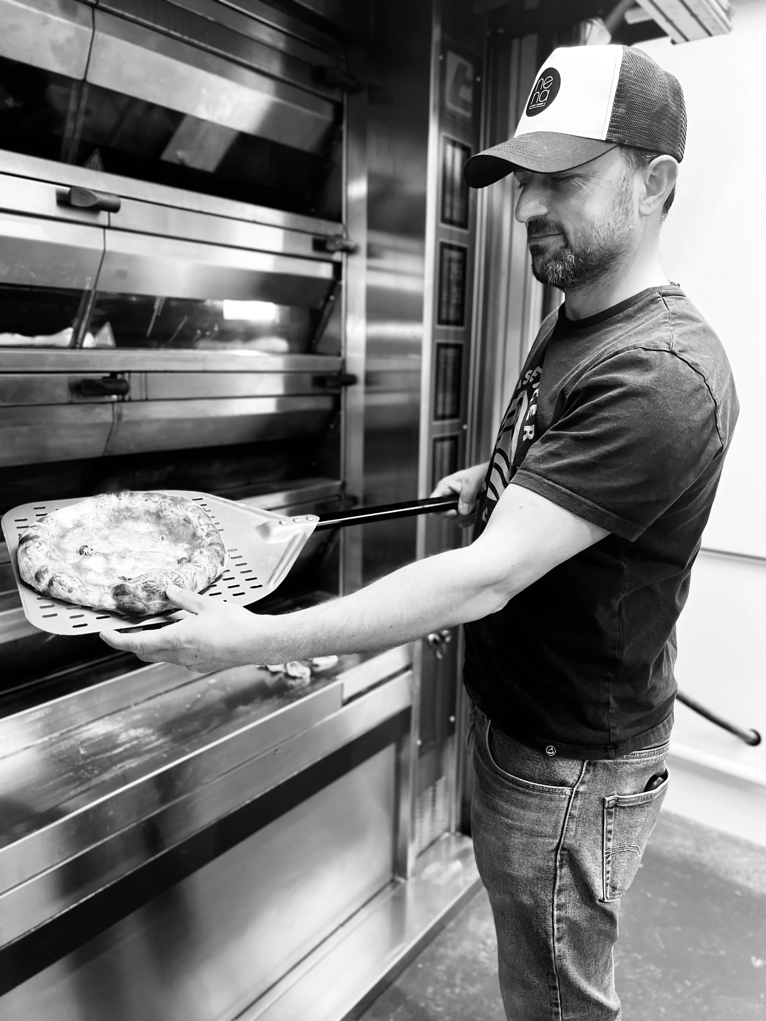 Zihni, the owner of Zini's Pizza Bar making Pizza