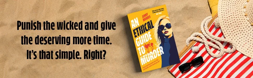 Book titled 'An Ethical Guide to Murder' placed on a sandy surface beside striped red and white fabric, sunglasses, and a multiple colors hat.