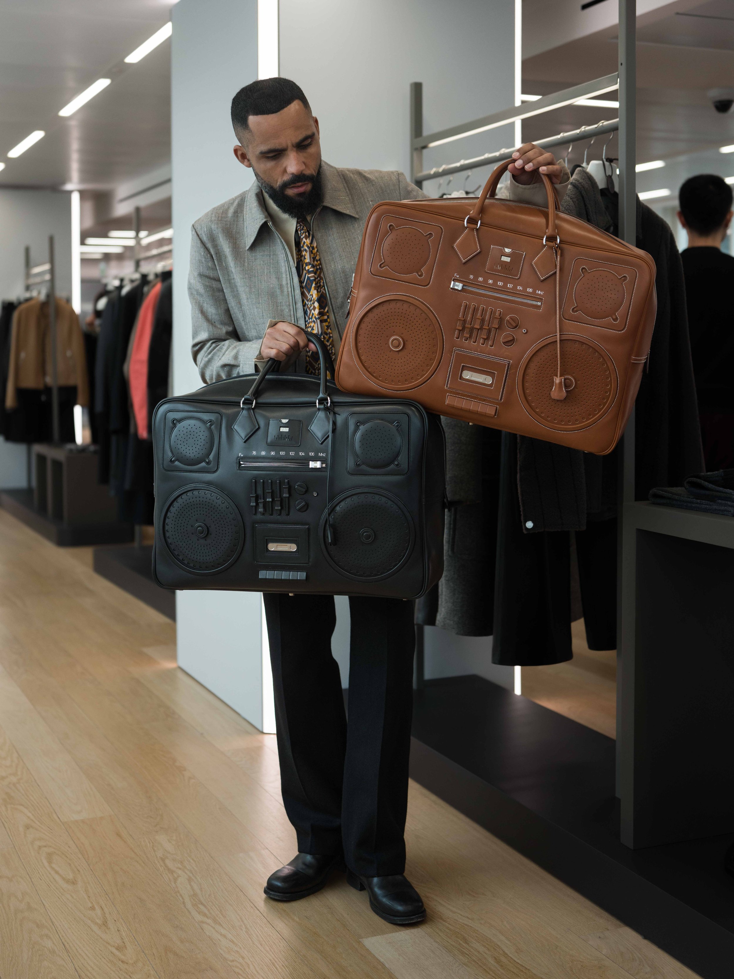 Jean-Claude Mpassy holding the new Hermès Plume Fourre-Tout On Radio Bag.