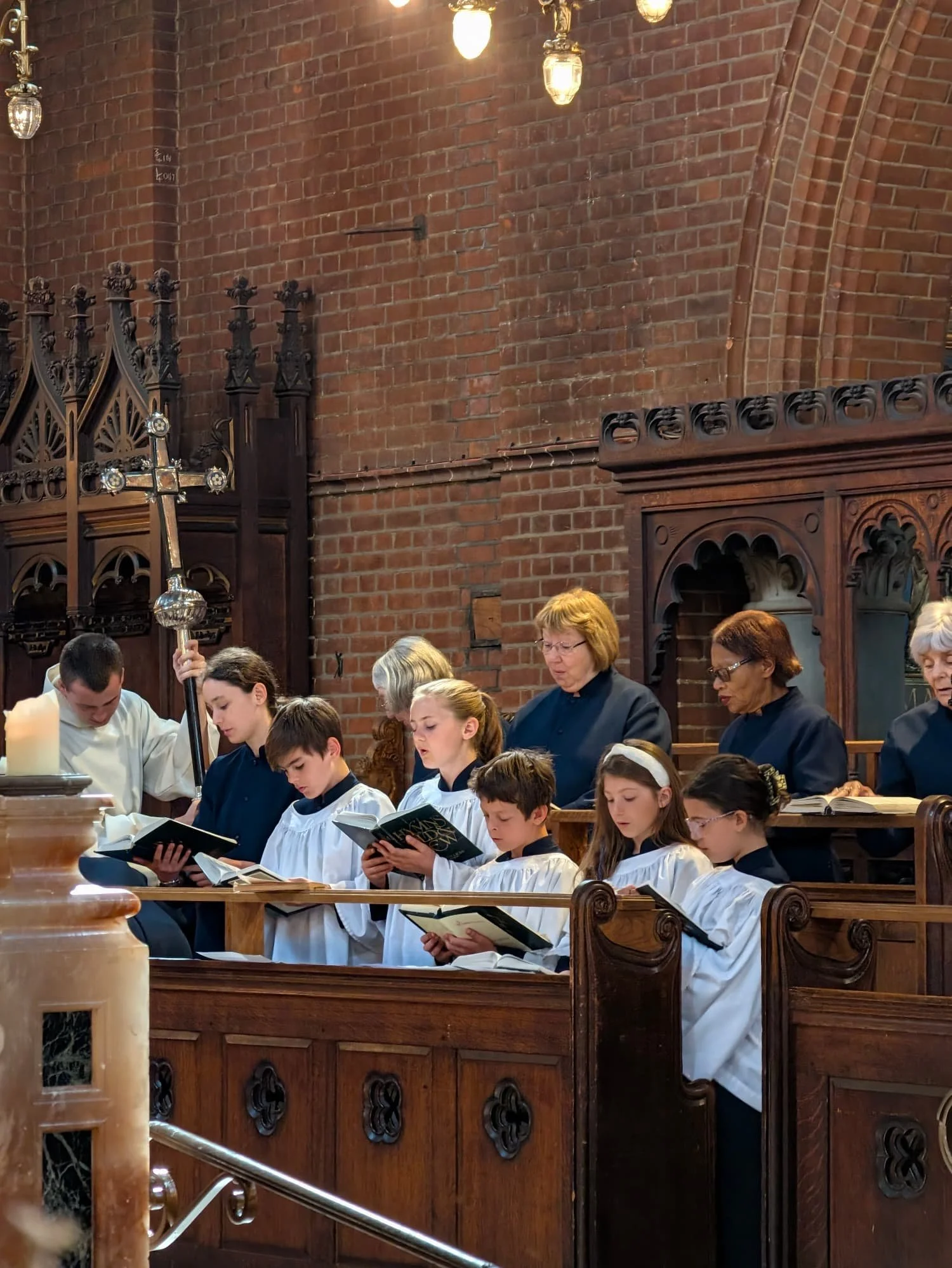 The choir members are singing from the choir pews