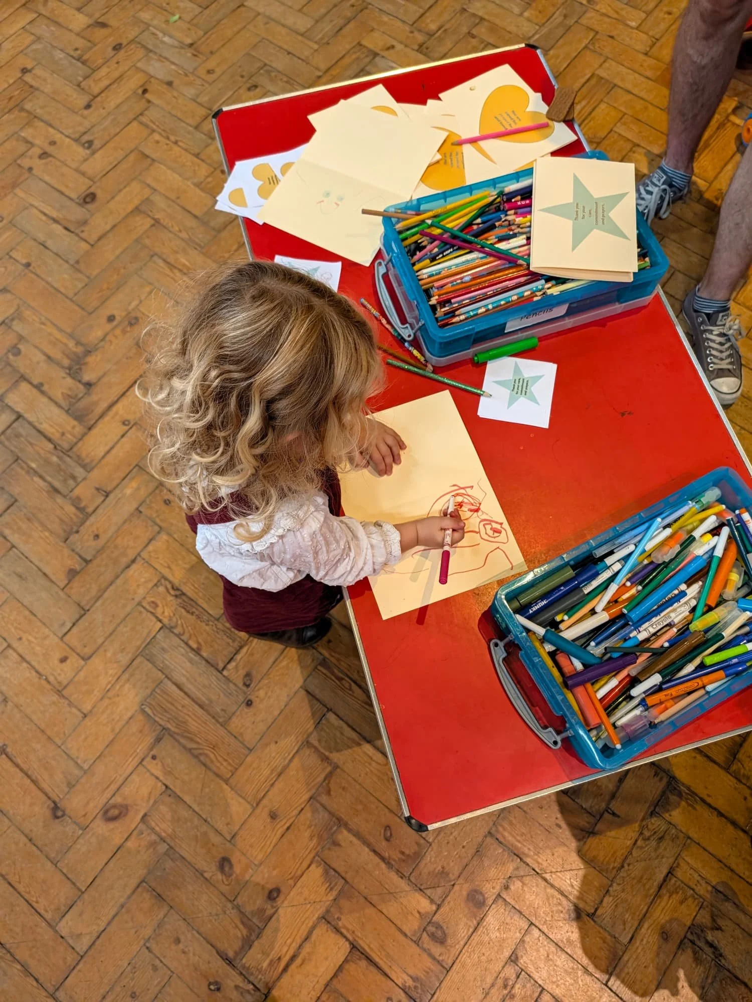Toddler drawing at a table in church