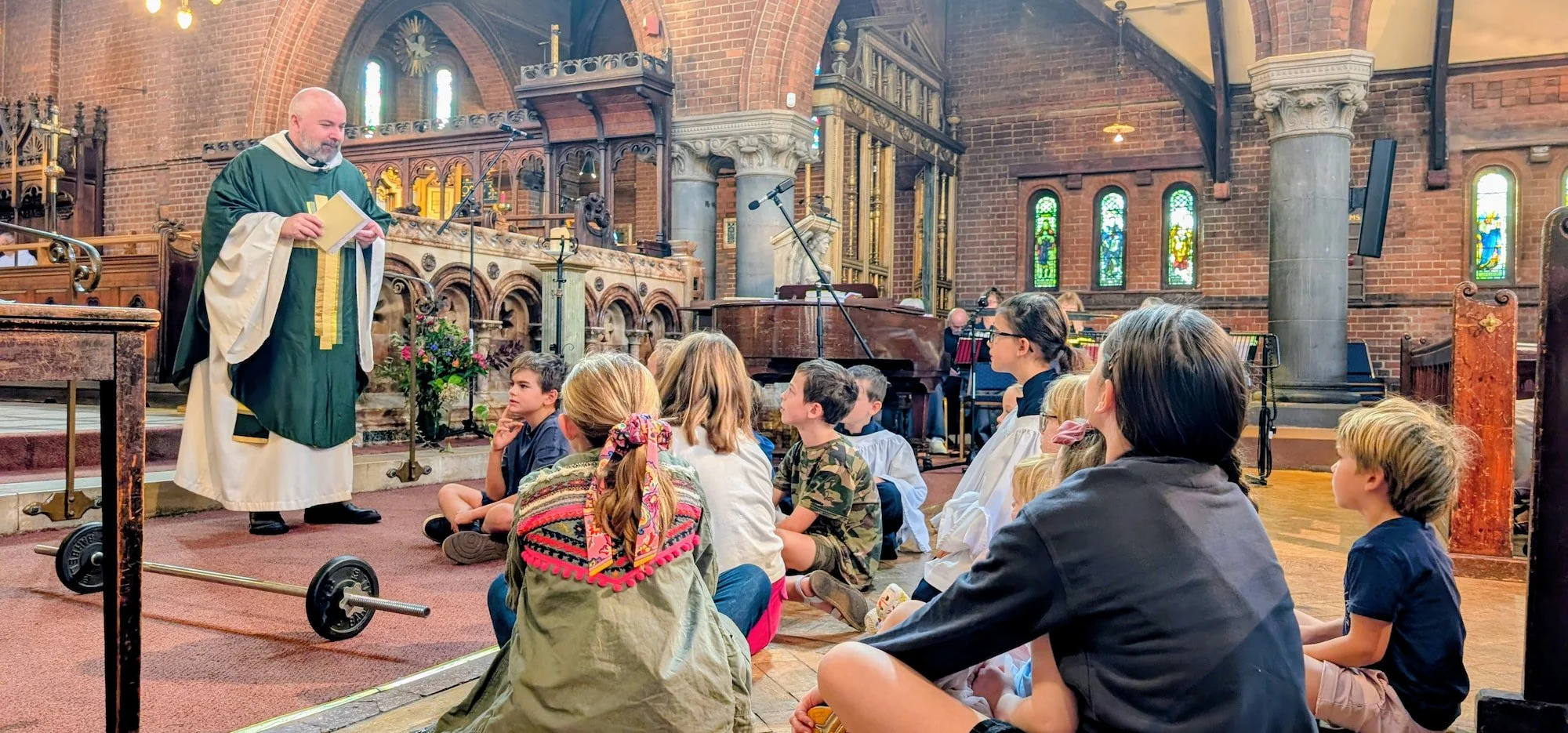 Children sit on the floor listening to the vicar