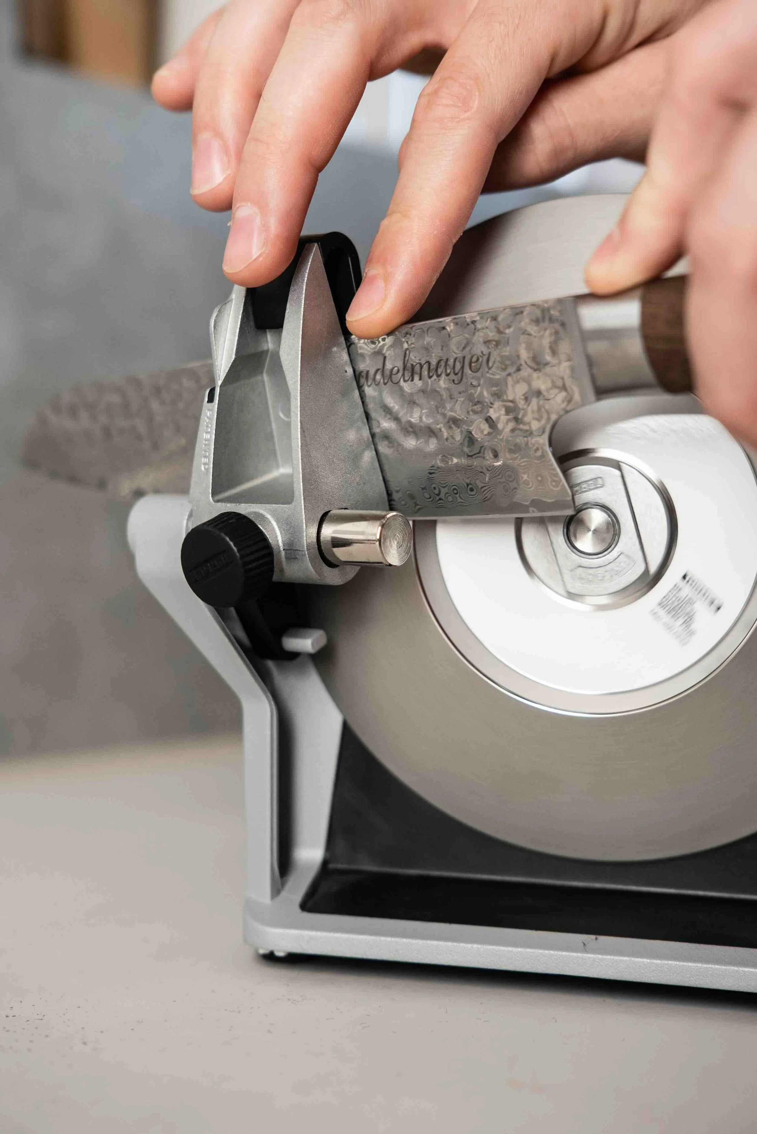 A person slicing a meat with a commercial meat slicer machine.