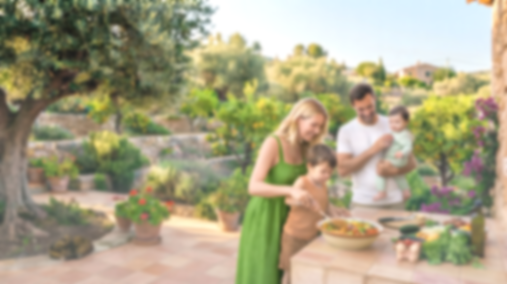 Famille préparant un repas en plein air dans un jardin ensoleillé avec des plantes autour.