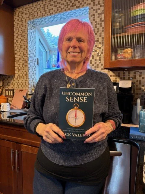 Linda holding her copy of Uncommon Sense by Jack Valerio.