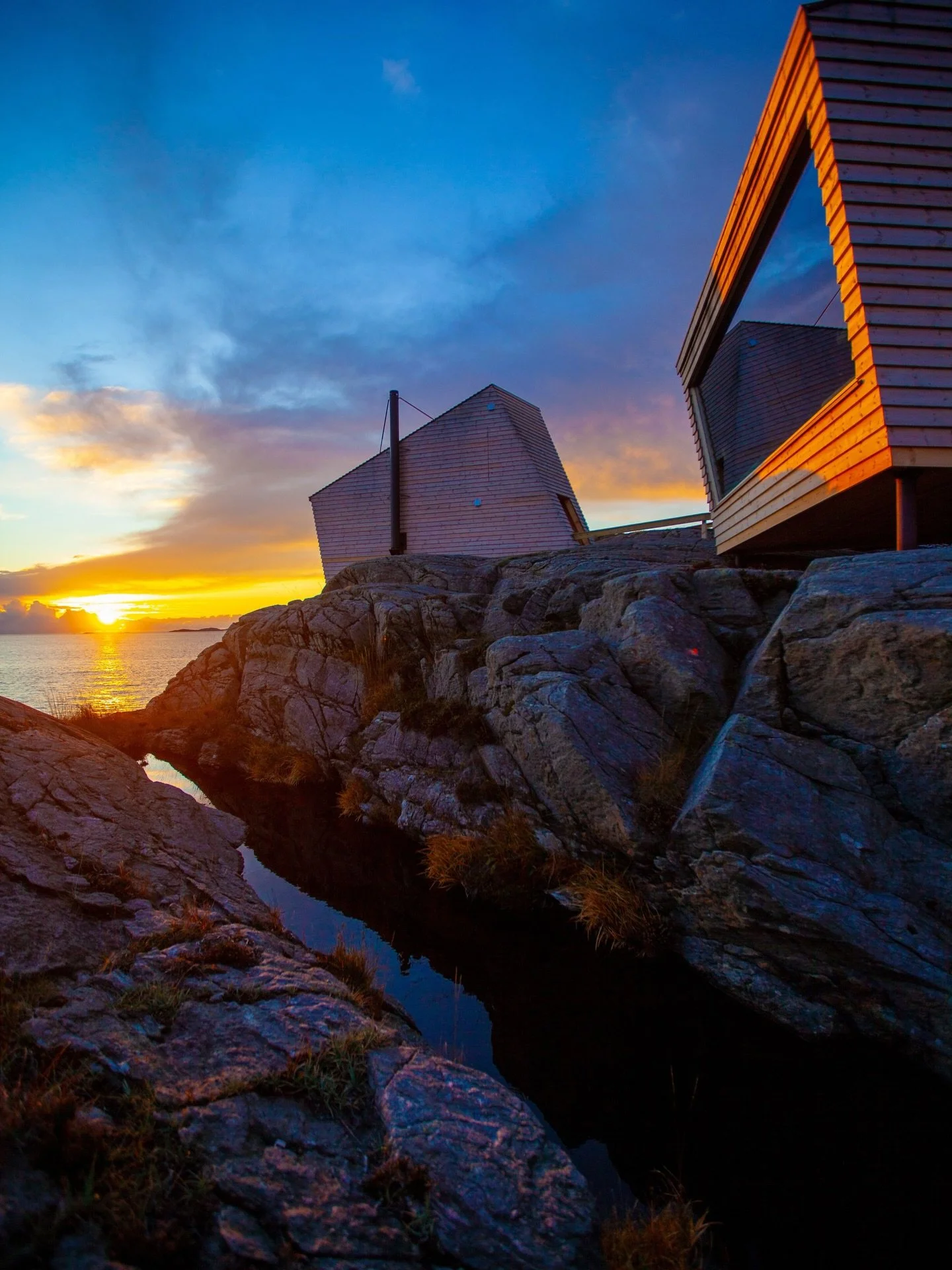 Experience stunning seaside architecture at Flokehyttene in Sveio 🧡 A stay at Flokehyttene is just as spectacular all year round &mdash; from quiet summer evenings with the sun setting on the horizon to autumn storms rolling in outside the panoramic